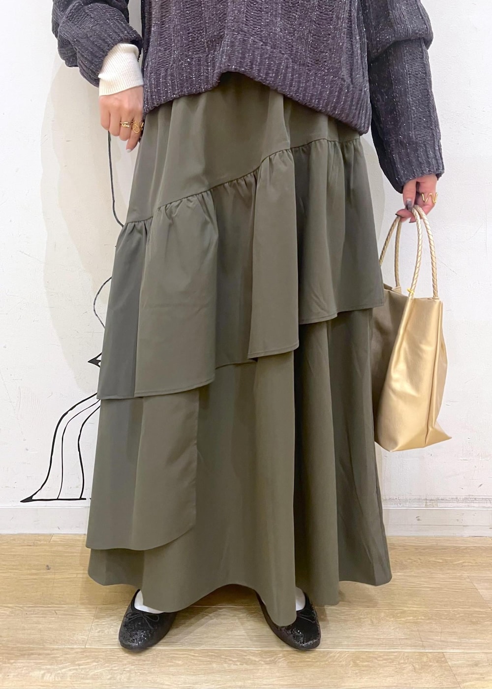 ホワイト系のニット/セーター、ブラック系のバレエシューズ、グリーン系のスカートを着用したレディースの冬コーディネートの7枚目の写真