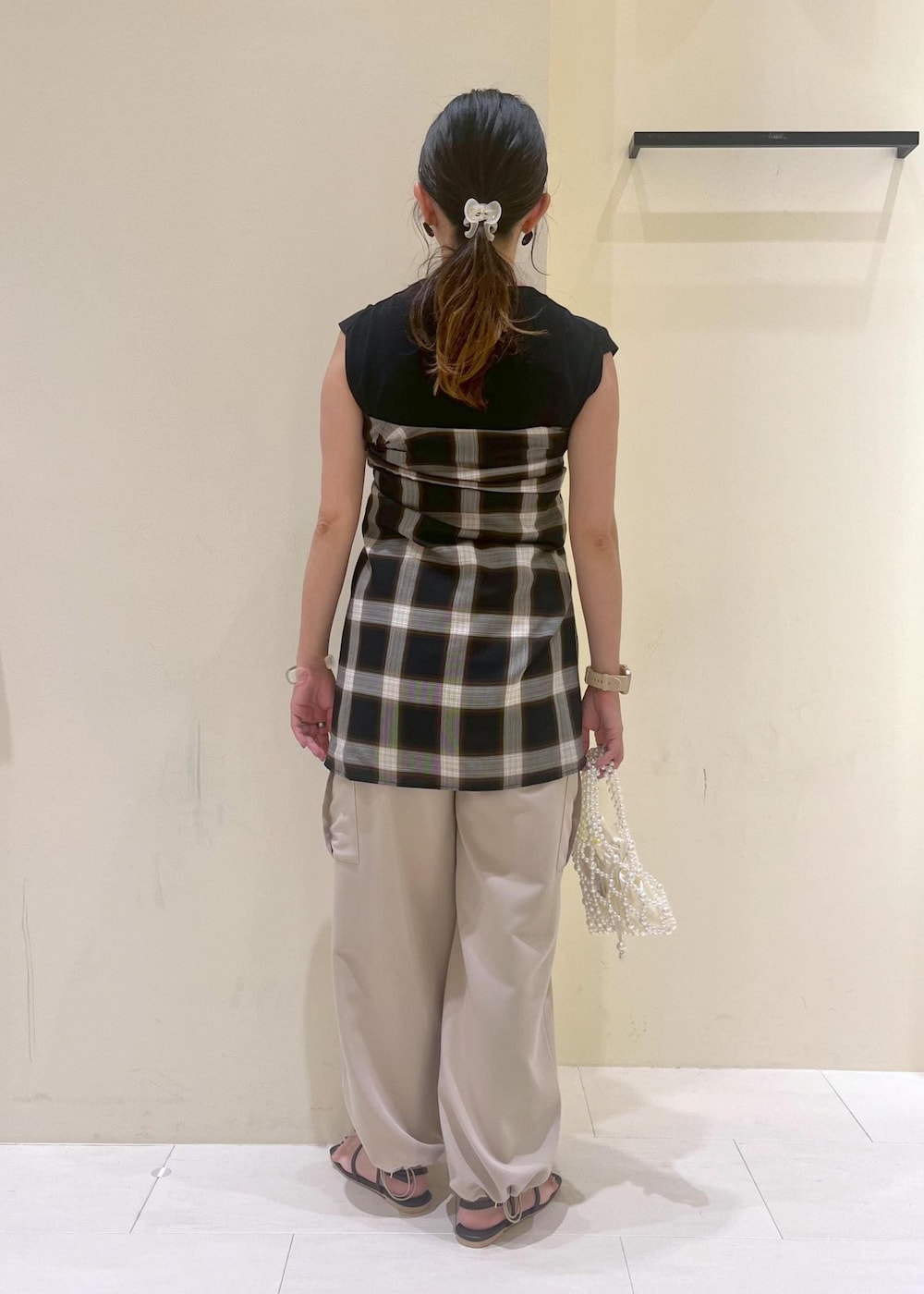 ブラック系のニット/セーター、ベージュ系のカーゴパンツ、ブラウン系のサンダルを着用したレディースの夏コーディネートの4枚目の写真