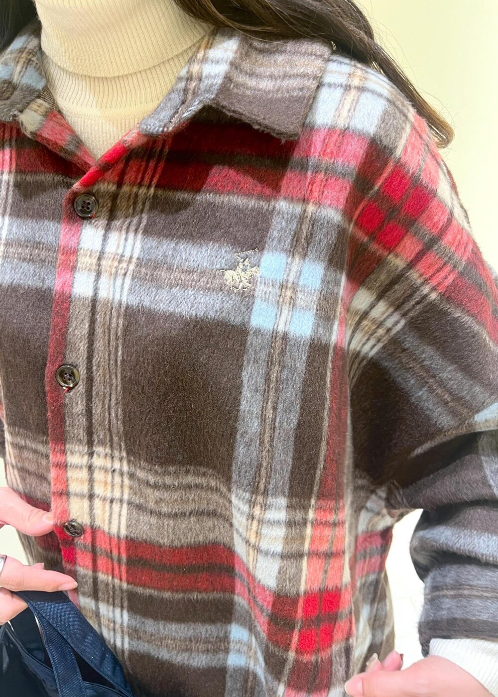 ブラウン系のシャツ/ブラウス、ホワイト系のニット/セーター、グレー系のスラックスを着用したレディースの冬コーディネートの5枚目の写真