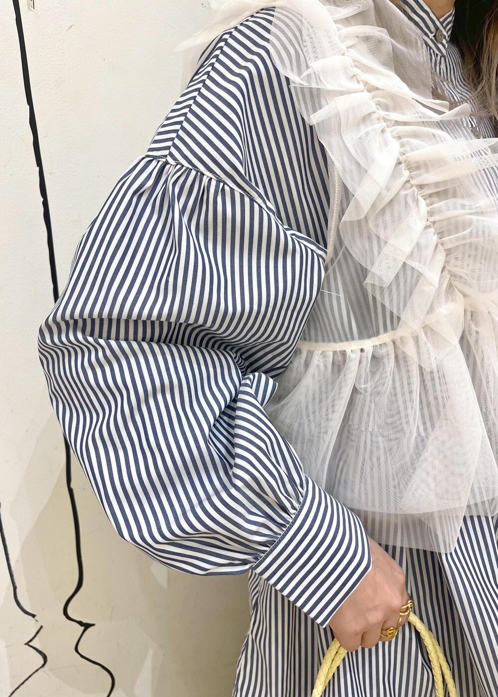 ホワイト系のベスト、ブルー系のその他パンツ、イエロー系のトートバッグを着用したレディースの冬コーディネートの7枚目の写真