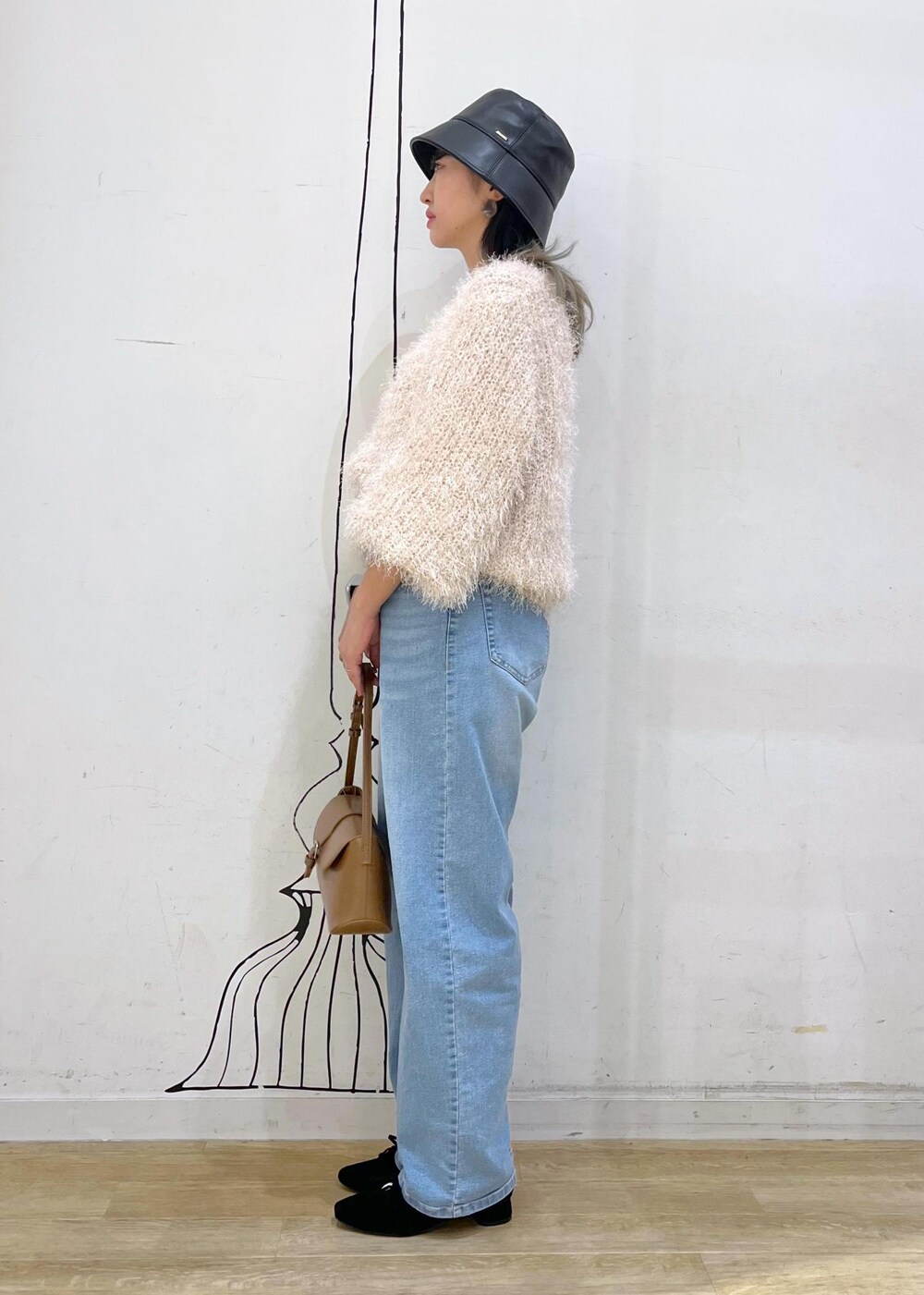 グレー系のタンクトップ、ブルー系のデニムパンツ、ベージュ系のカーディガン/ボレロを着用したレディースの秋コーディネートの4枚目の写真