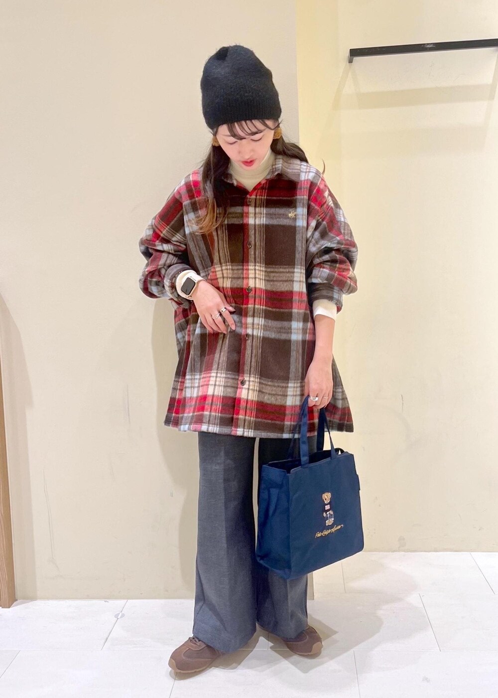 ブラウン系のシャツ/ブラウス、ホワイト系のニット/セーター、グレー系のスラックスを着用したレディースの冬コーディネートの2枚目の写真