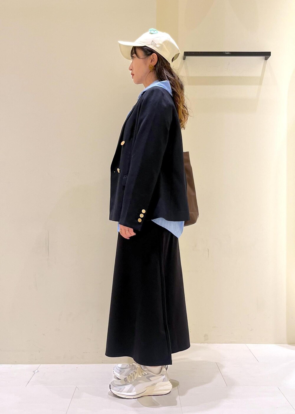 ブラウン系のトートバッグ、ブラウン系のトートバッグ、ブルー系のテーラードジャケットを着用したレディースの秋コーディネートの4枚目の写真