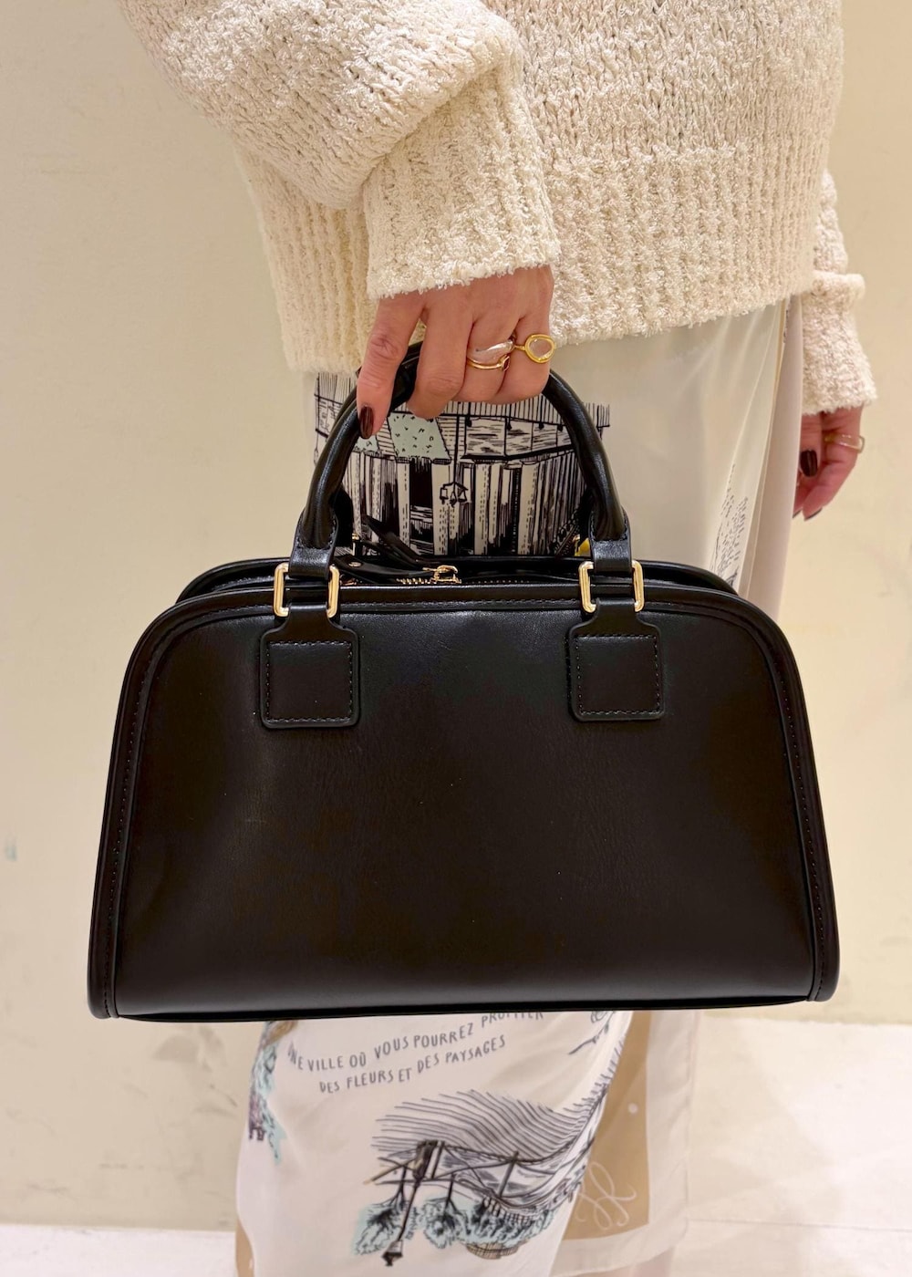 ブラック系のボストンバッグ、ベージュ系のその他パンツ、ホワイト系のニット/セーターを着用したレディースの冬コーディネートの8枚目の写真