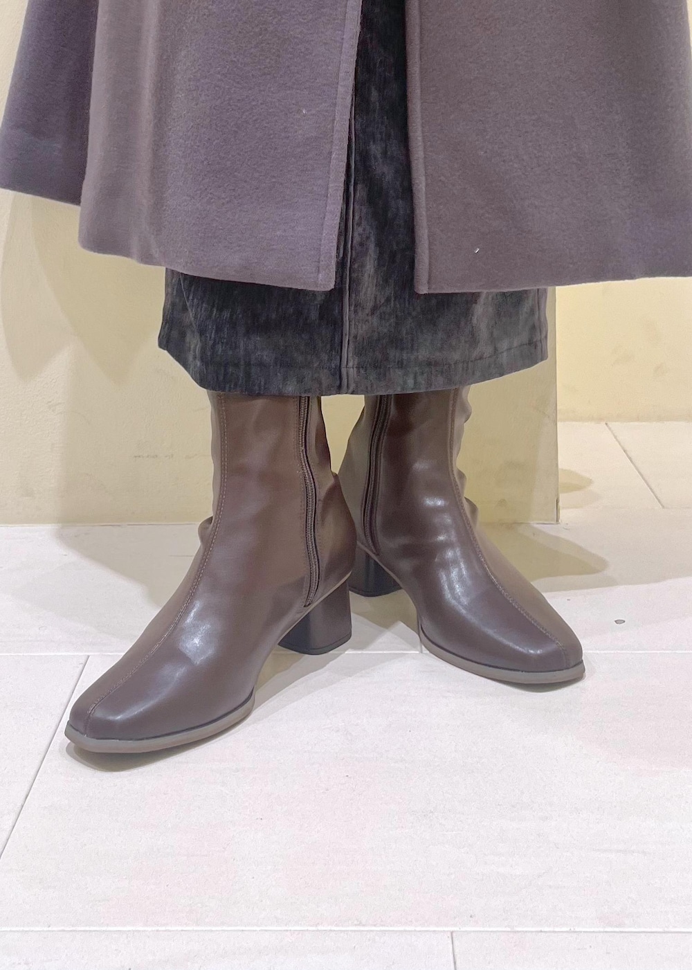 グレー系のスカート、ブラック系のカーディガン/ボレロ、ホワイト系のニット/セーターを着用したレディースの冬コーディネートの9枚目の写真