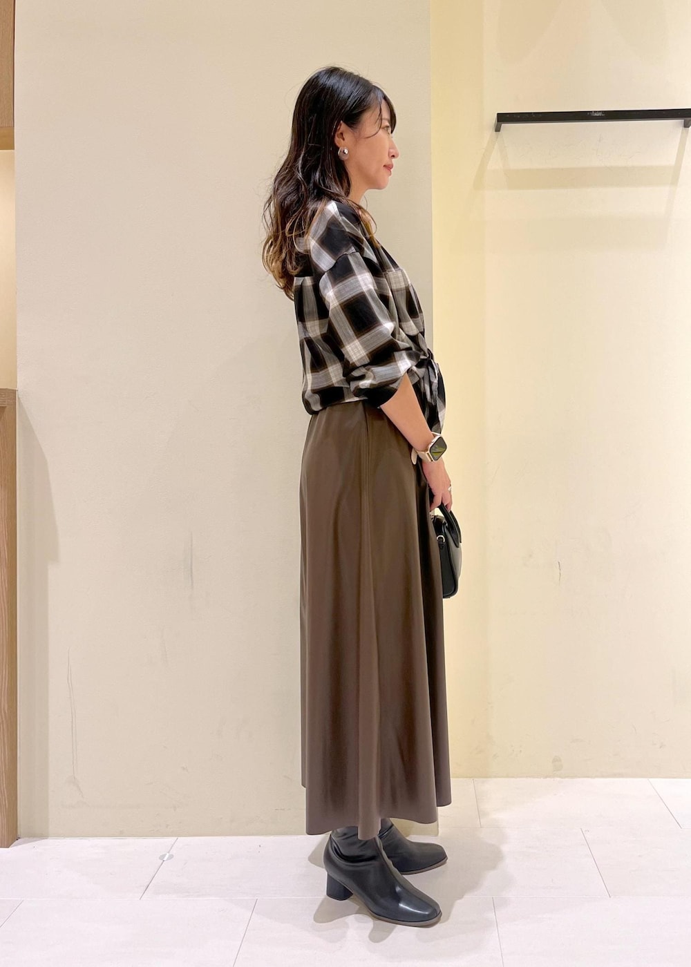 ブラック系のシャツ/ブラウス、グリーン系のスカート、ブラック系のブーツを着用したレディースの秋コーディネートの3枚目の写真