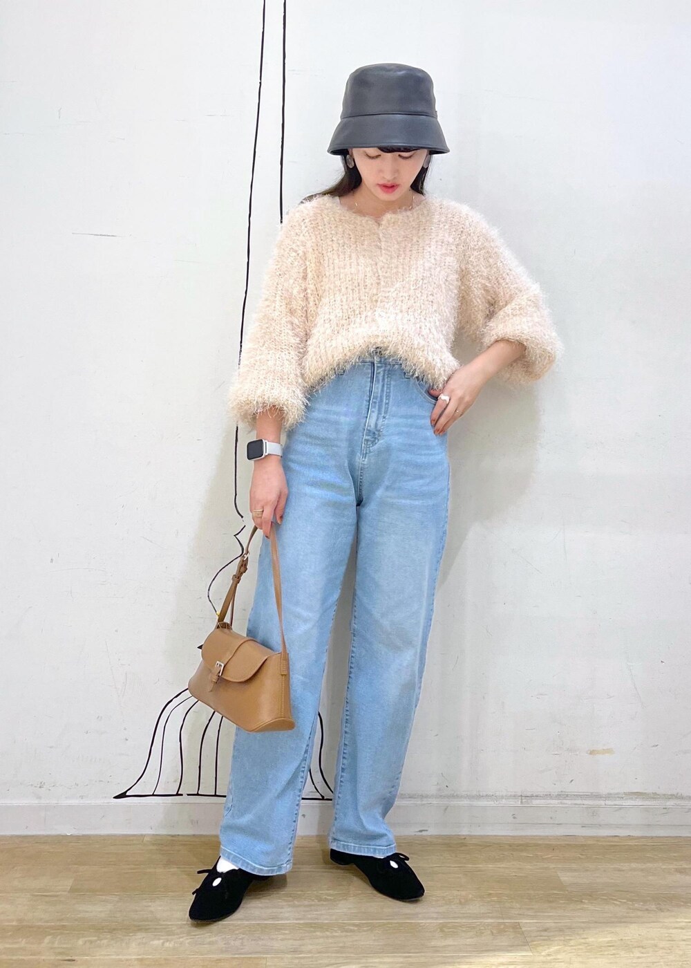 グレー系のタンクトップ、ブルー系のデニムパンツ、ベージュ系のカーディガン/ボレロを着用したレディースの秋コーディネートの2枚目の写真