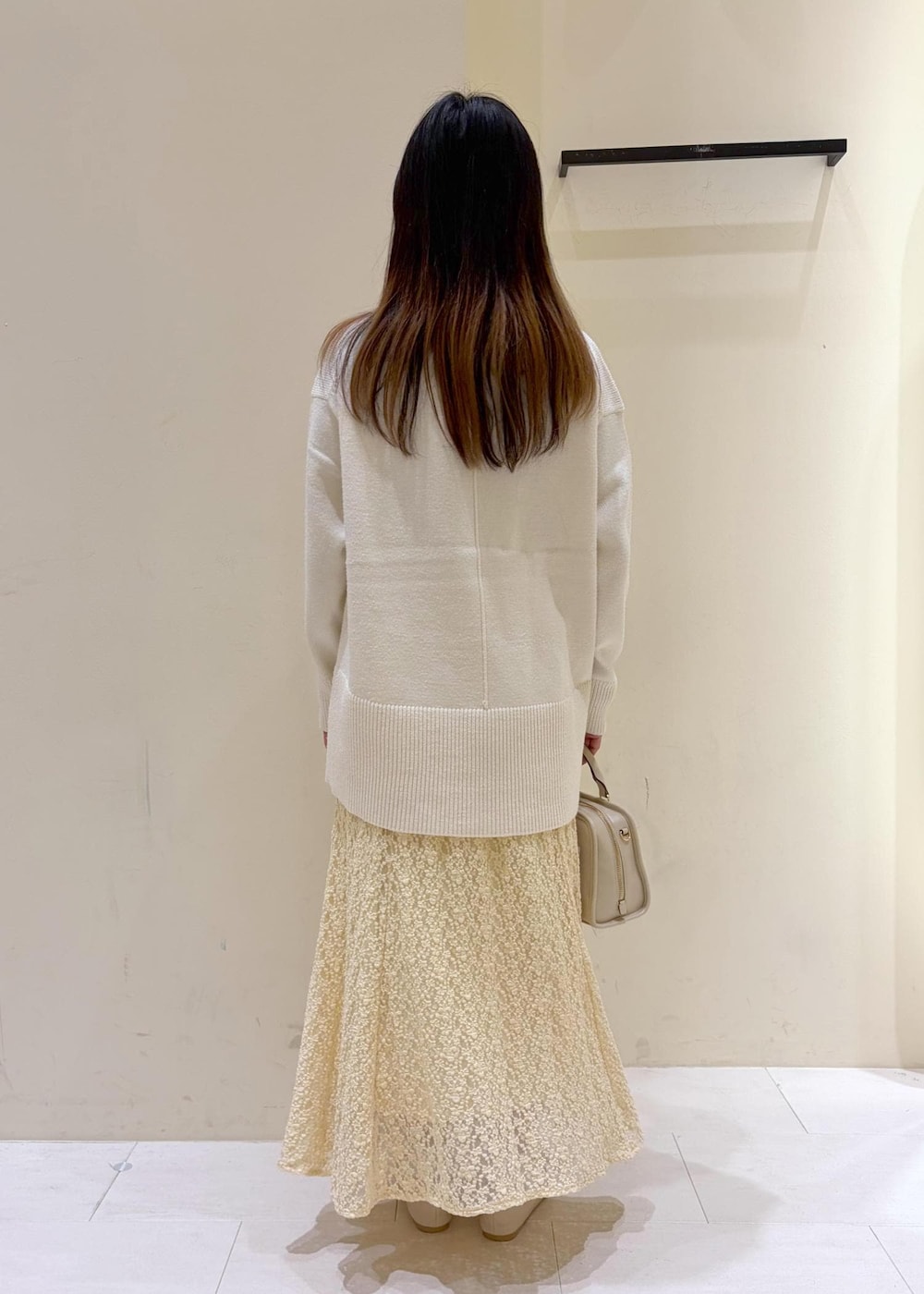 ホワイト系のバレエシューズ、ホワイト系のニット/セーター、ホワイト系のボストンバッグを着用したレディースの冬コーディネートの4枚目の写真