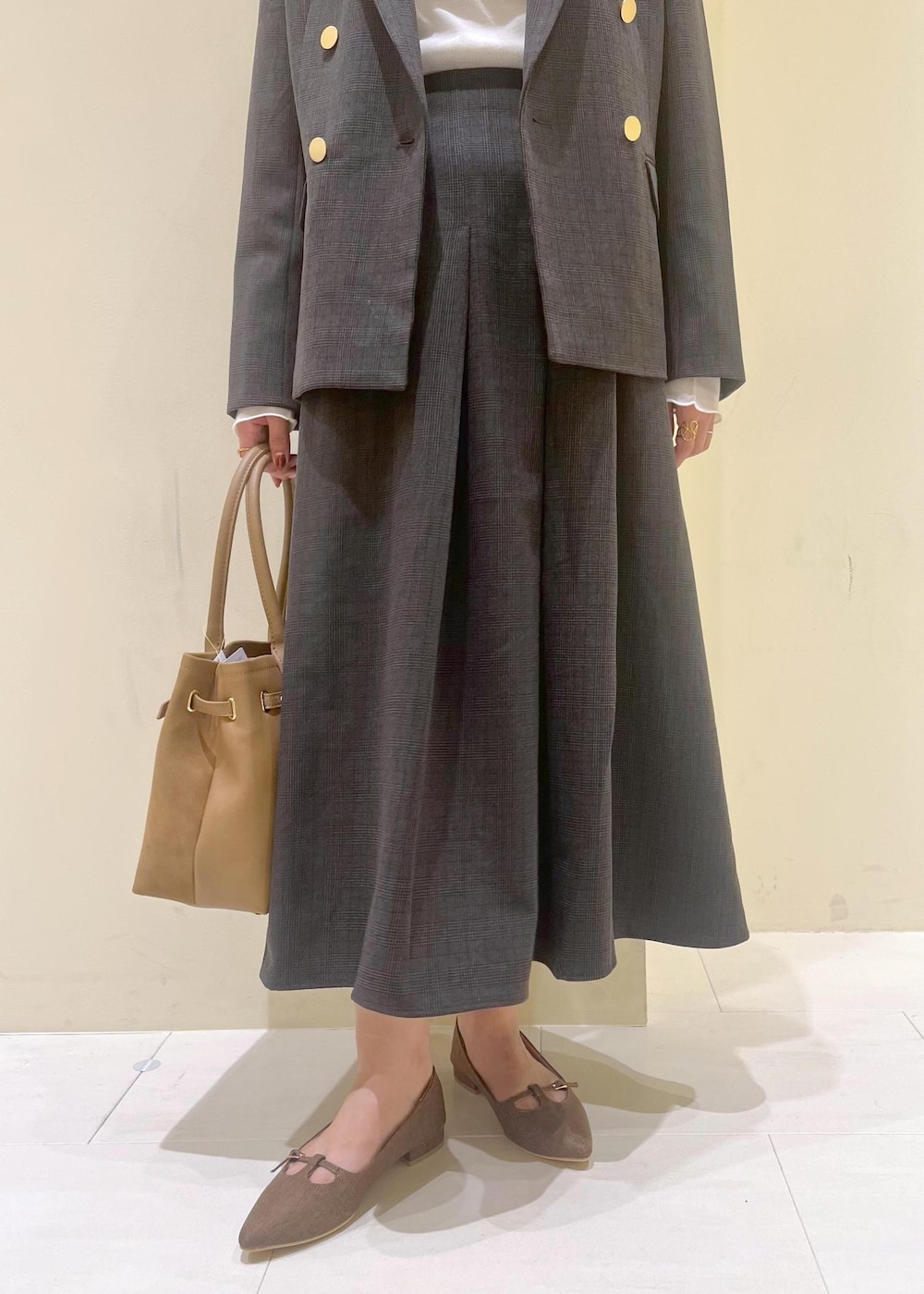 ブラック系のスカート、ブラック系のテーラードジャケット、ホワイト系のTシャツ/カットソーを着用したレディースの秋コーディネートの8枚目の写真