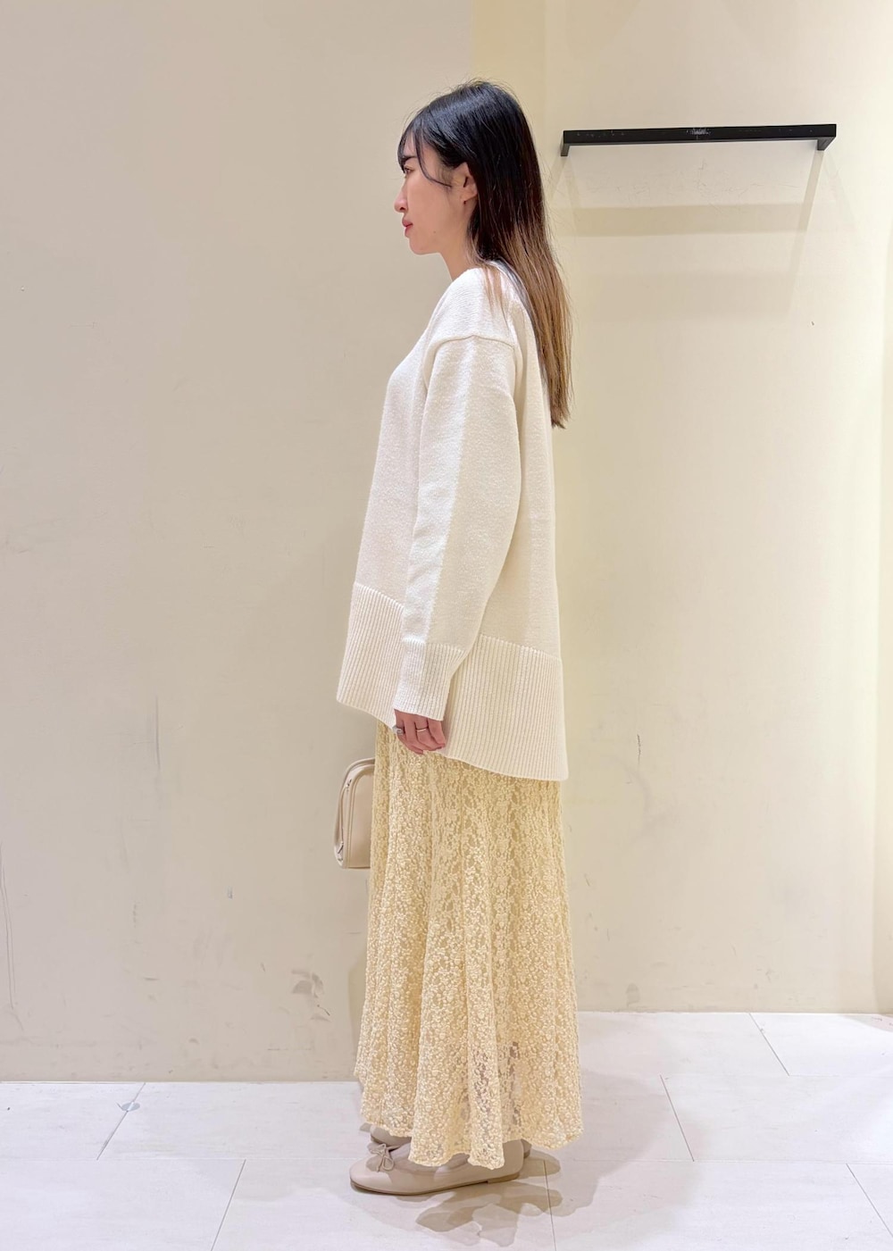 ホワイト系のバレエシューズ、ホワイト系のニット/セーター、ホワイト系のボストンバッグを着用したレディースの冬コーディネートの3枚目の写真