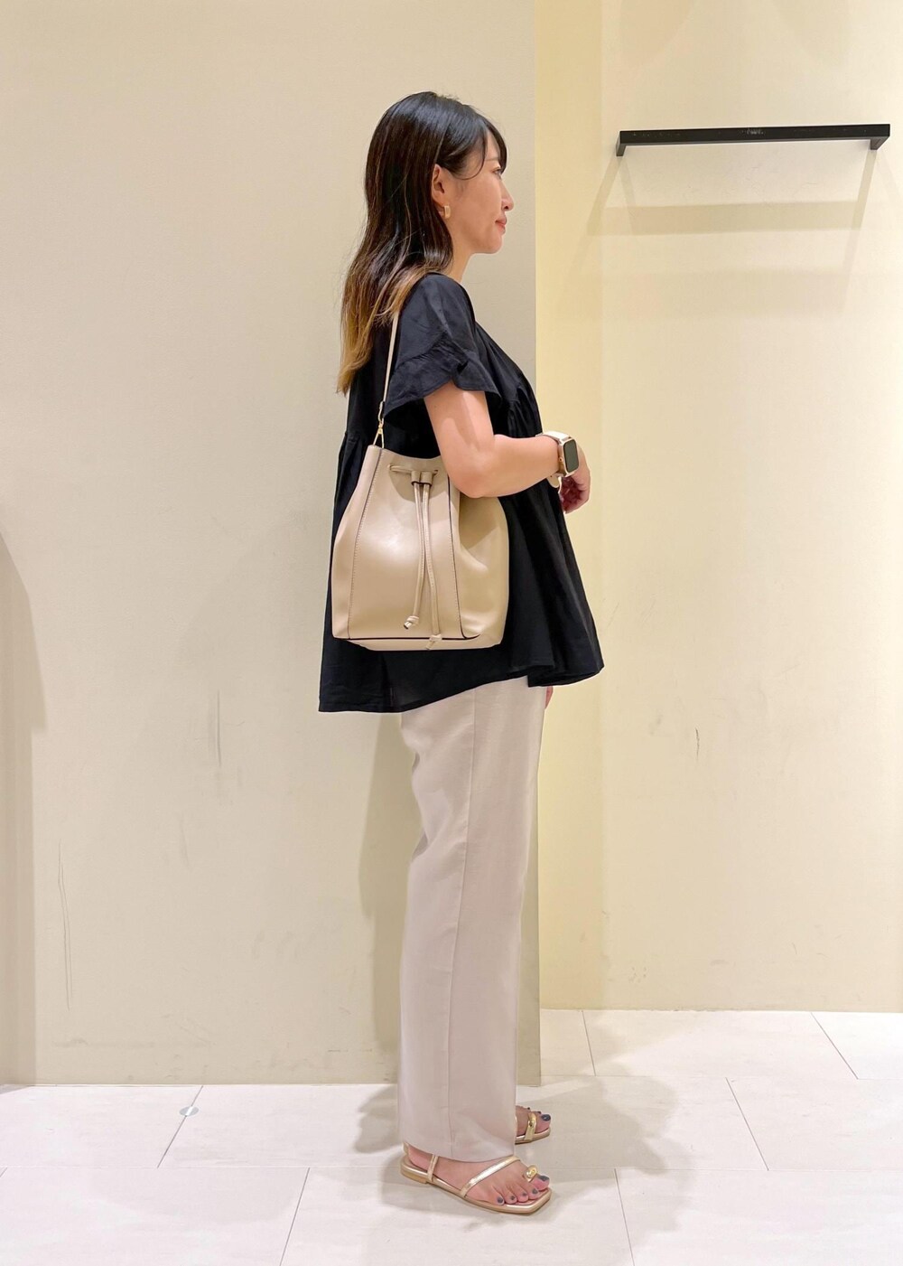 ブラック系のシャツ/ブラウス、グレー系のその他パンツ、ゴールド系のサンダルを着用したレディースの夏コーディネートの3枚目の写真