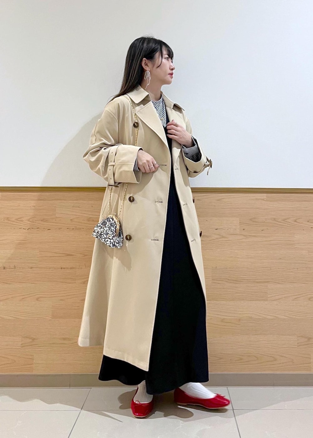 グレー系のショルダーバッグ、ブルー系のシャツ/ブラウス、ベージュ系のトレンチコートを着用したレディースの冬コーディネートの3枚目の写真