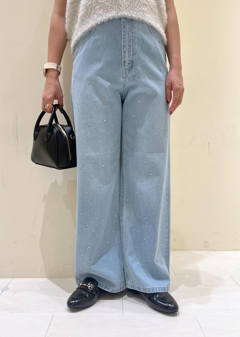 ブルー系のデニムパンツ、グレー系のベスト、ブラック系のローファーを着用したレディースの秋コーディネートの7枚目の写真