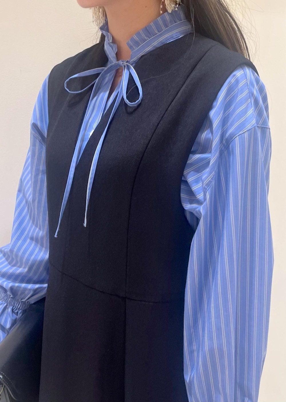 ホワイト系のバレエシューズ、ブラック系のショルダーバッグ、ブラック系のジャンパースカートを着用したレディースの冬コーディネートの5枚目の写真