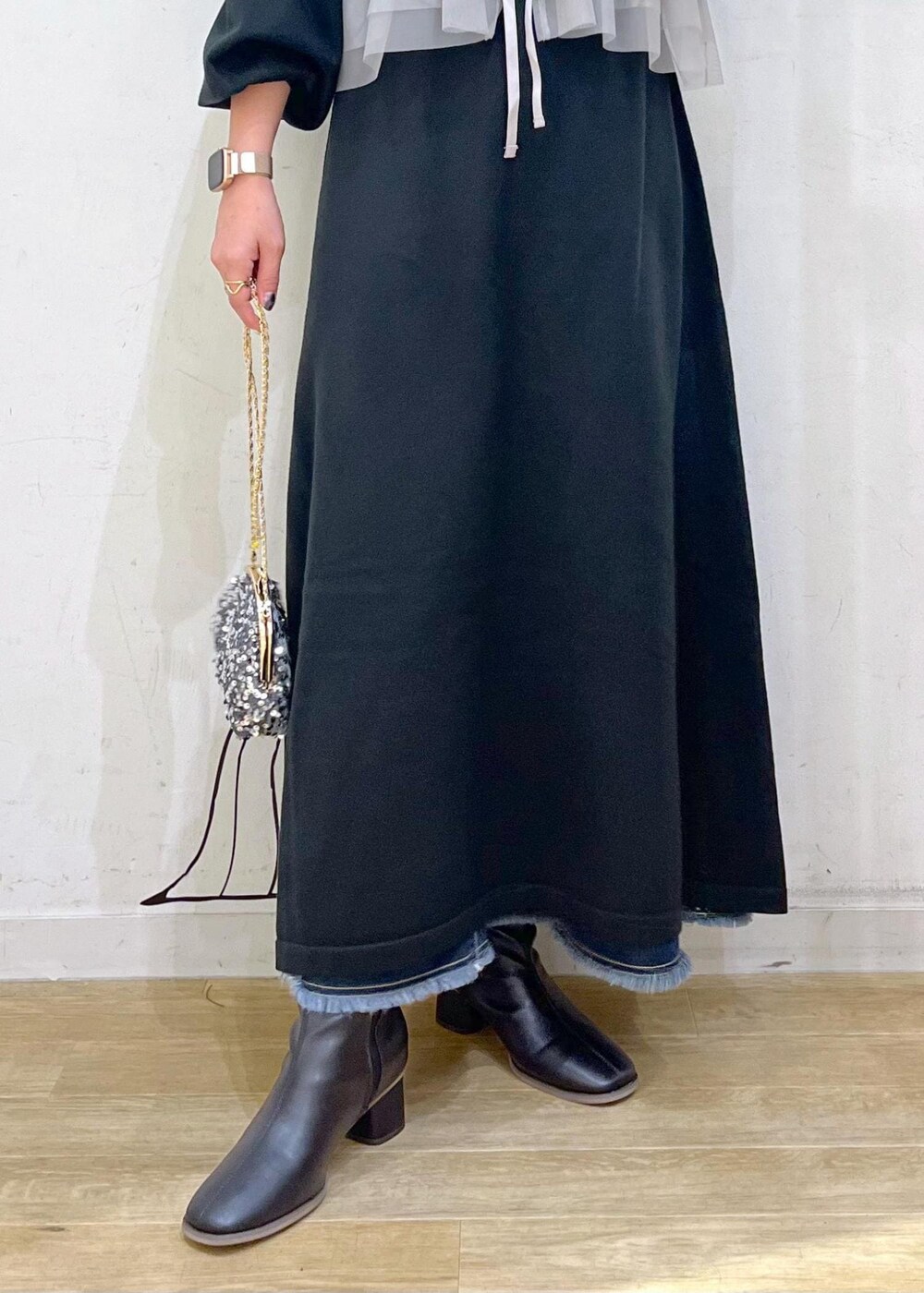 ブルー系のデニムスカート、ブラック系のブーツ、ブラック系のワンピースを着用したレディースの冬コーディネートの7枚目の写真