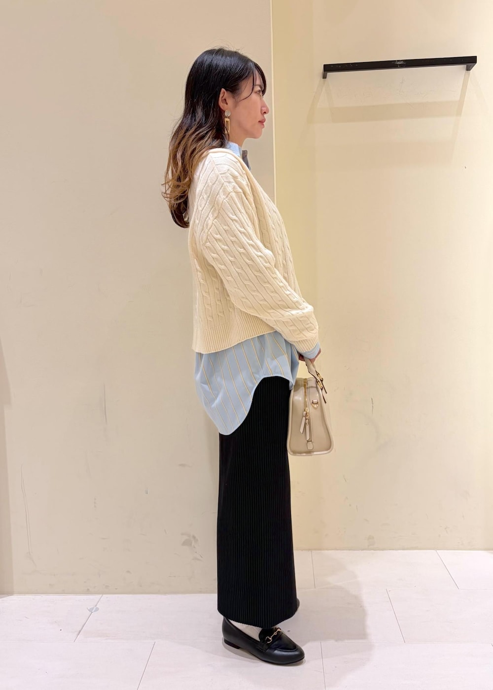 ホワイト系のニット/セーター、ブラック系のローファー、ホワイト系のボストンバッグを着用したレディースの冬コーディネートの2枚目の写真