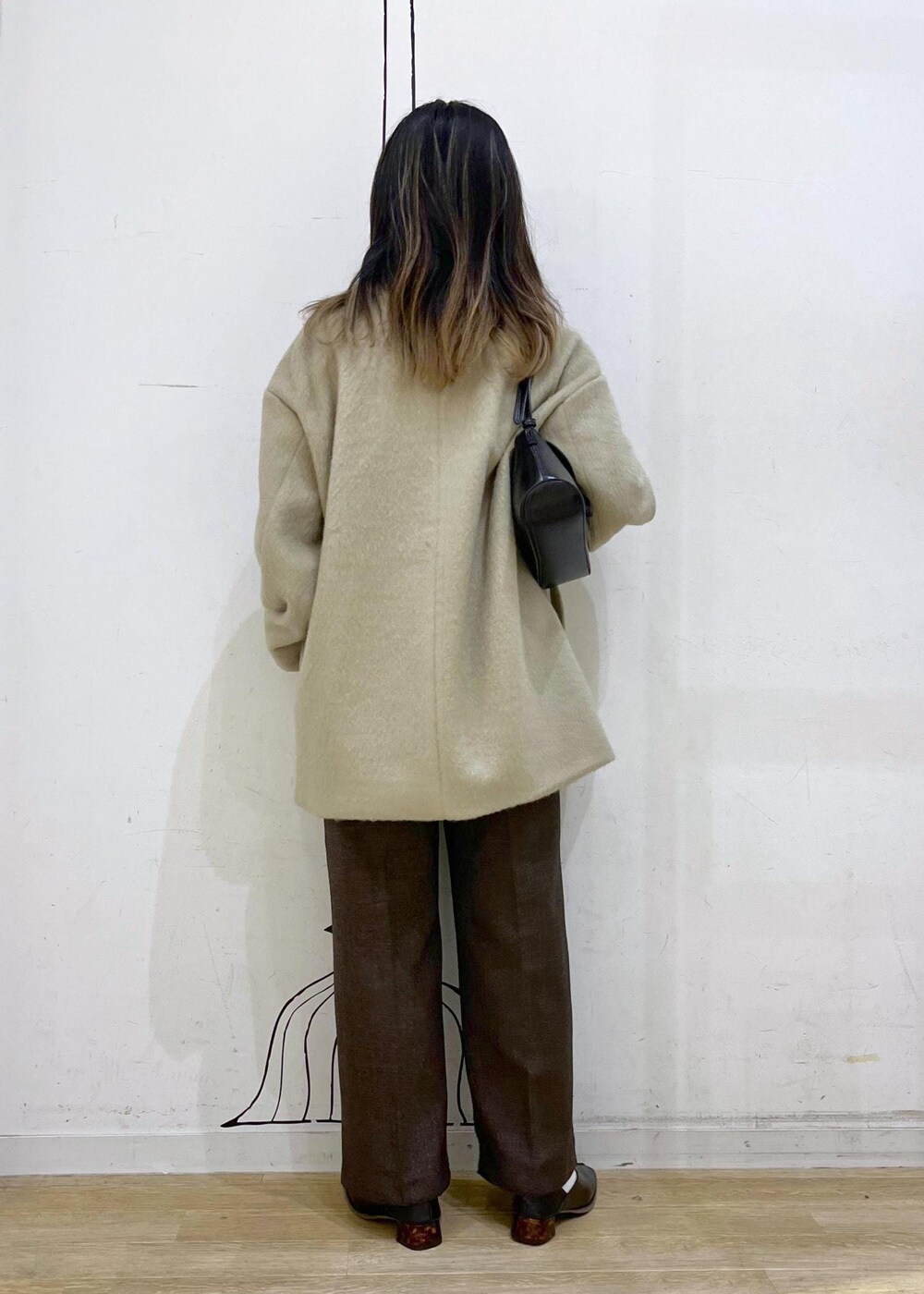 ホワイト系のニット/セーター、グリーン系のその他アウター、ブラウン系のその他パンツを着用したレディースの冬コーディネートの3枚目の写真