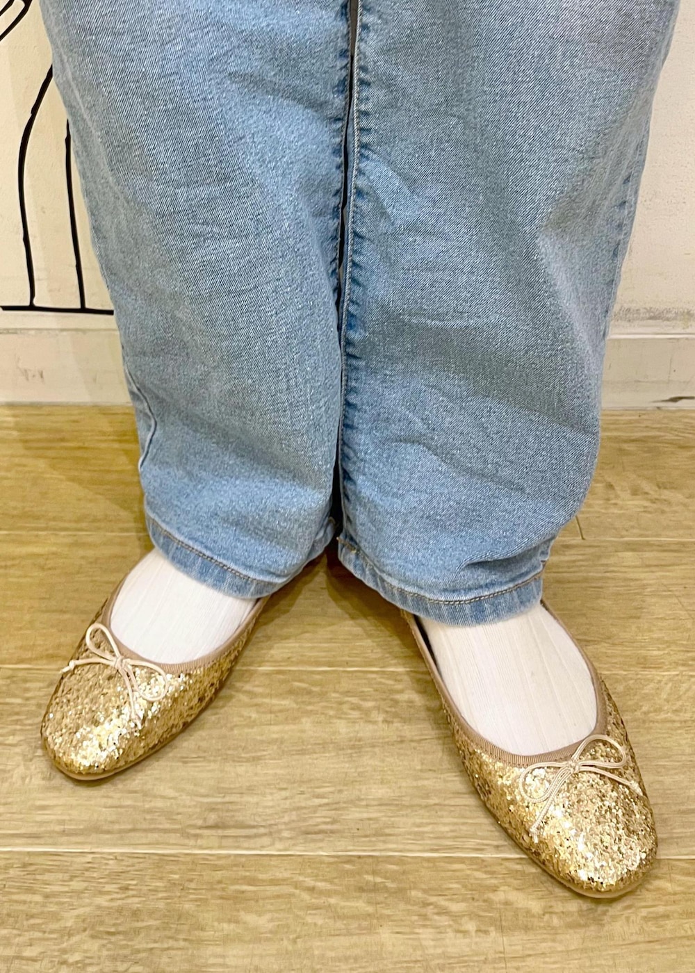 ブラック系のニット/セーター、ゴールド系のバレエシューズ、ホワイト系のキャミソールを着用したレディースの冬コーディネートの10枚目の写真