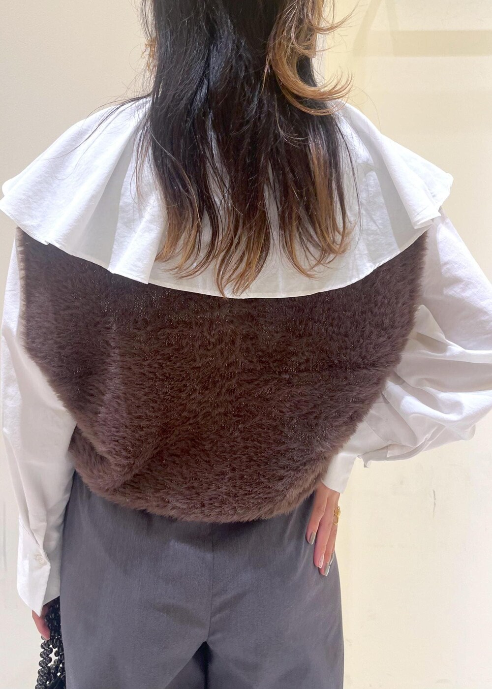 ホワイト系のシャツ/ブラウス、ブラック系のハンドバッグ、ブラウン系のベストを着用したレディースの秋コーディネートの6枚目の写真