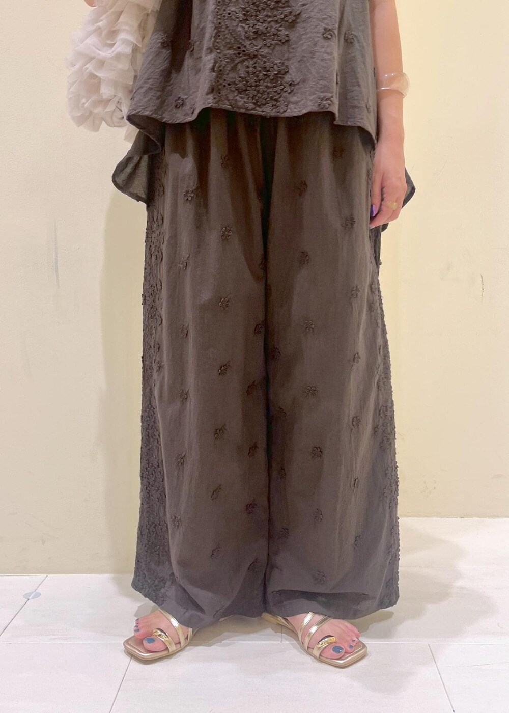 ベージュ系のショルダーバッグ、ゴールド系のサンダル、ブラック系のシャツ/ブラウスを着用したレディースの夏コーディネートの8枚目の写真