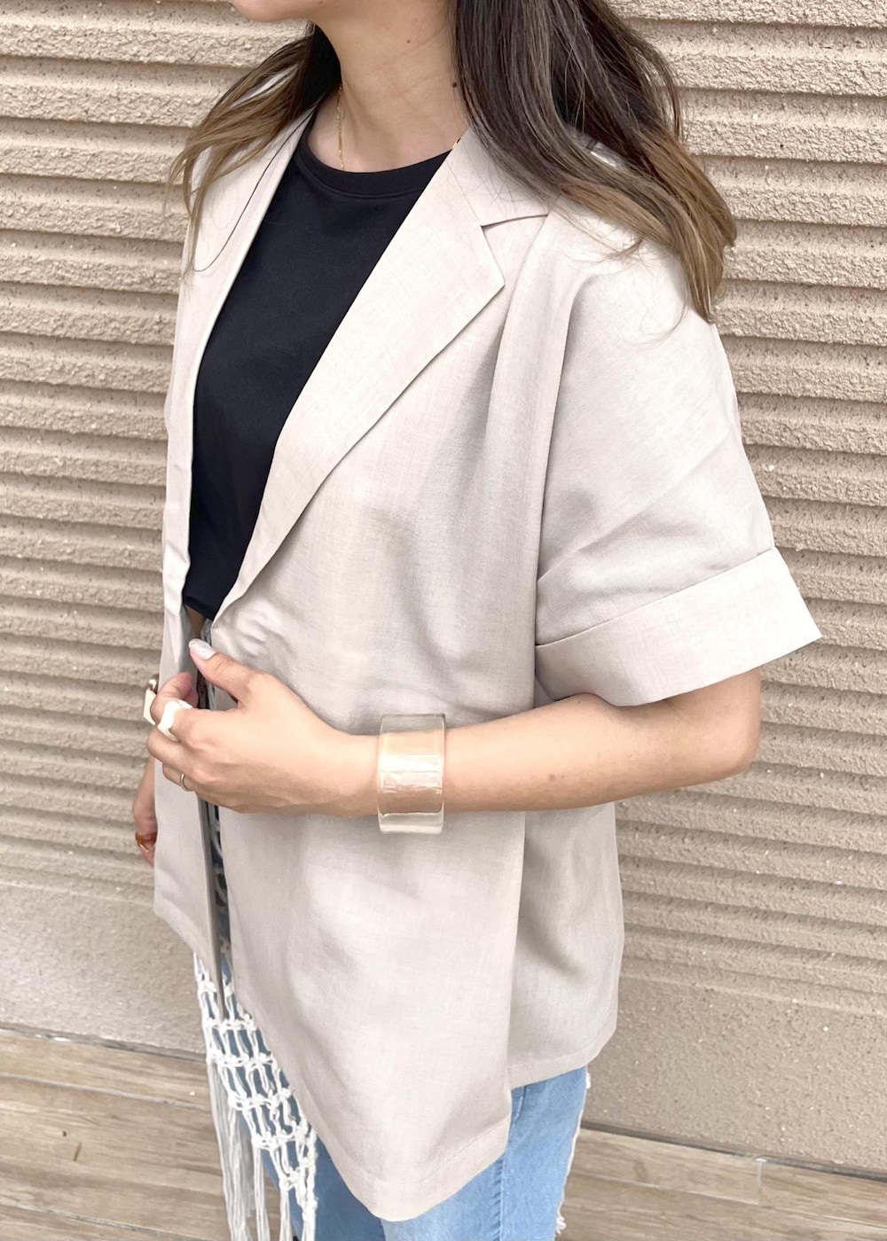 ブルー系のデニムパンツ、ホワイト系のスカート、ブラック系のTシャツ/カットソーを着用したレディースの春コーディネートの6枚目の写真