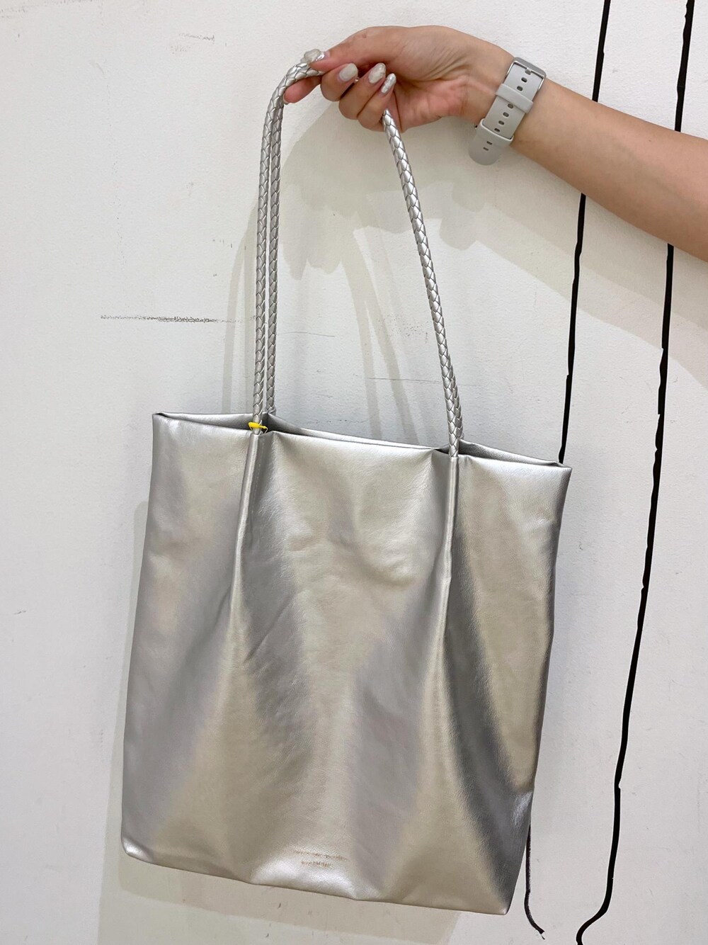 シルバー系のトートバッグ、ベージュ系のタンクトップ、ブラック系のワンピースを着用したレディースの夏コーディネートの9枚目の写真