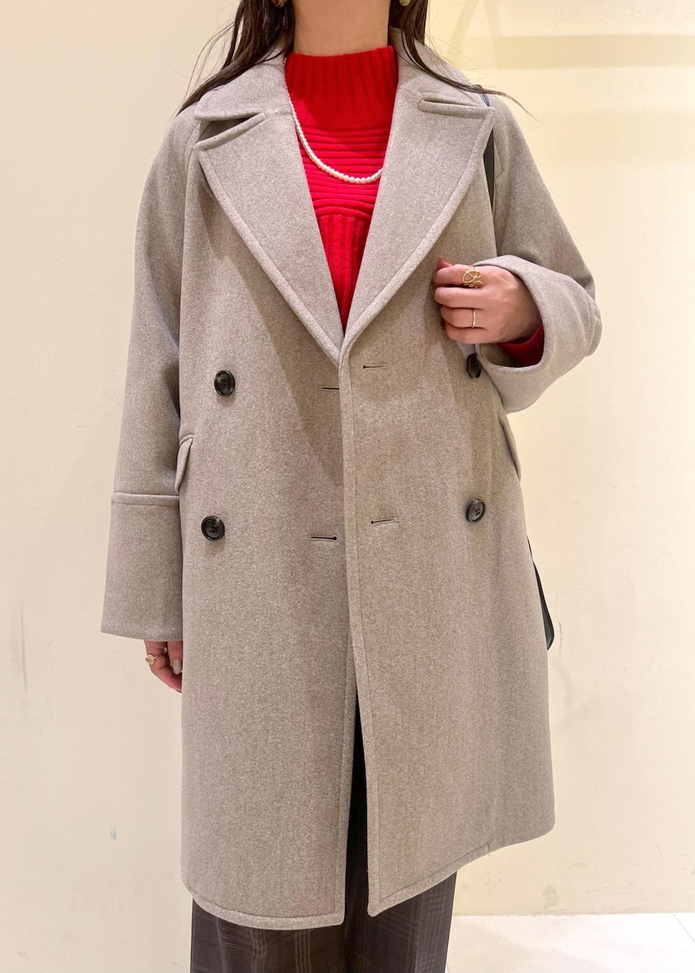 ブラック系のショルダーバッグ、レッド系のニット/セーター、ブラウン系のピーコートを着用したレディースの秋コーディネートの6枚目の写真