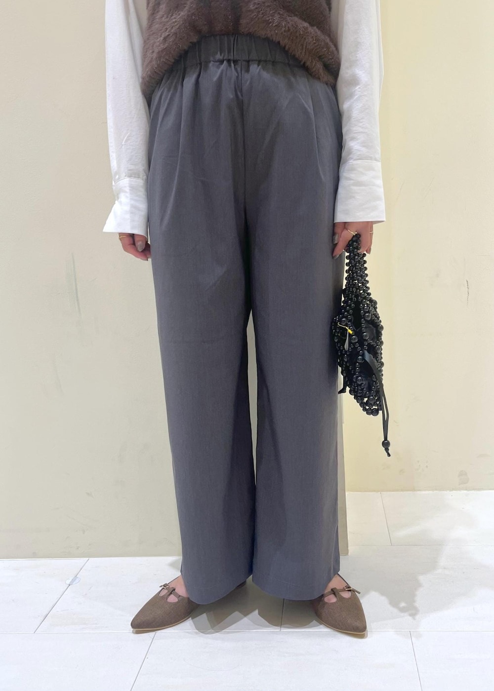 ホワイト系のシャツ/ブラウス、ブラック系のハンドバッグ、ブラウン系のベストを着用したレディースの秋コーディネートの8枚目の写真