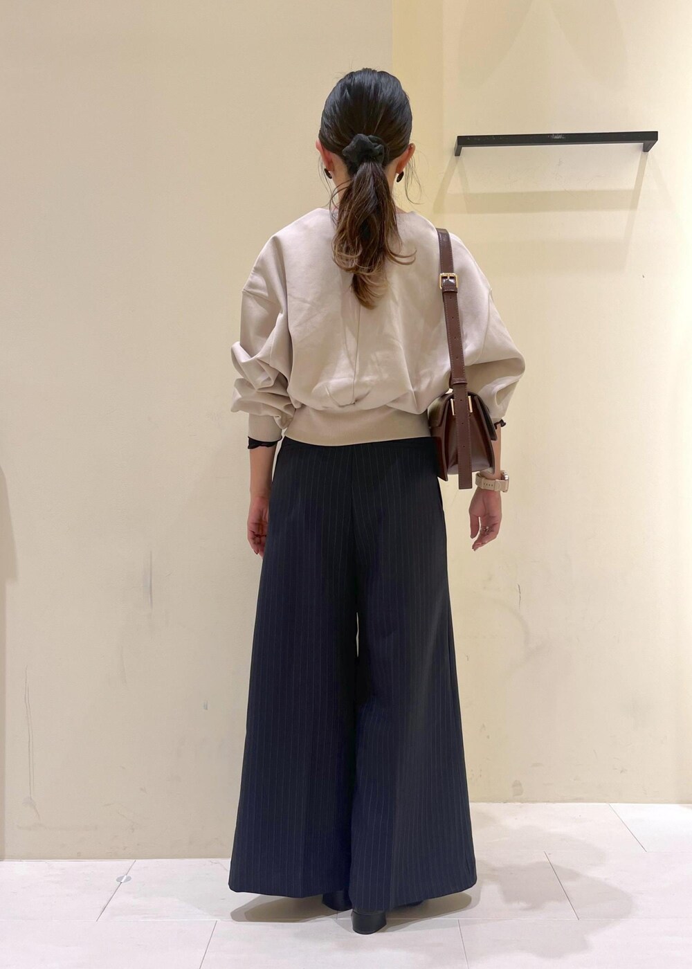 レッド系のショルダーバッグ、ブルー系のその他パンツ、ブラック系のTシャツ/カットソーを着用したレディースの秋コーディネートの3枚目の写真