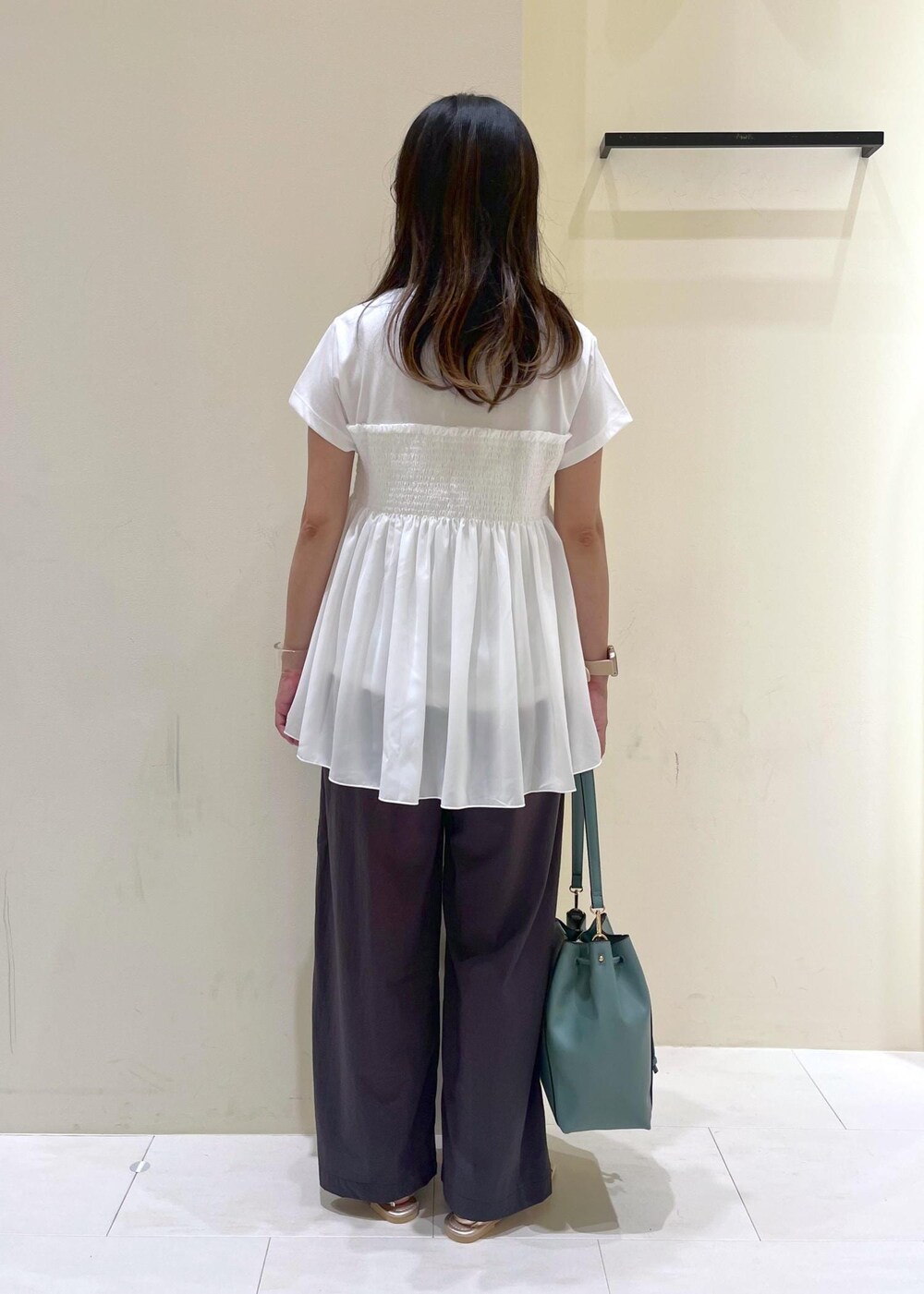 ブルー系のショルダーバッグ、グレー系のその他パンツ、ゴールド系のサンダルを着用したレディースの夏コーディネートの4枚目の写真