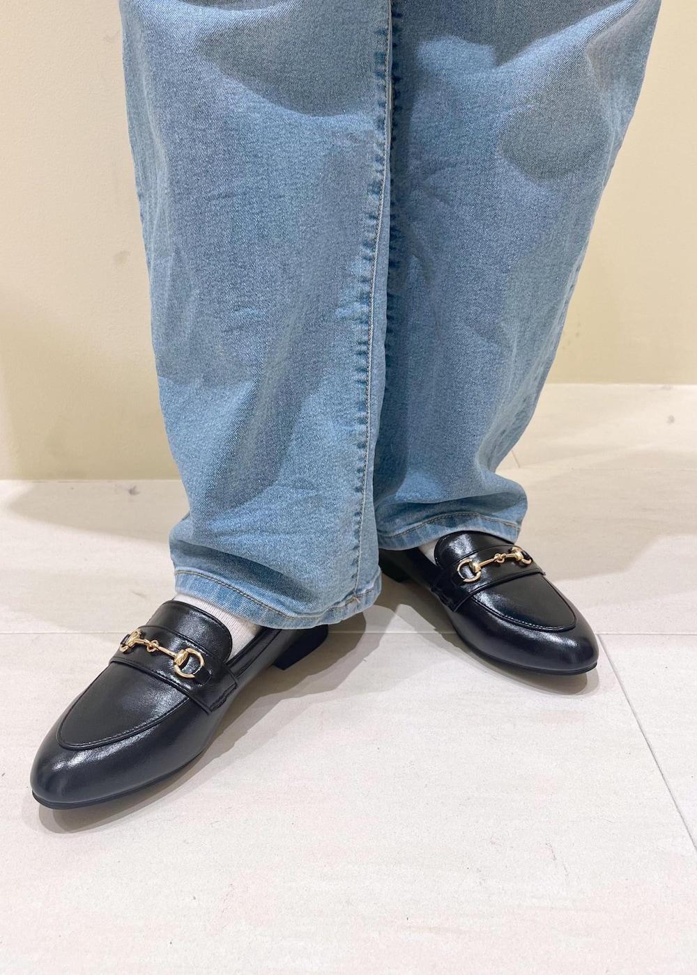 ブルー系のデニムパンツ、ホワイト系のキャミソール、ブラック系のハンドバッグを着用したレディースの春コーディネートの10枚目の写真