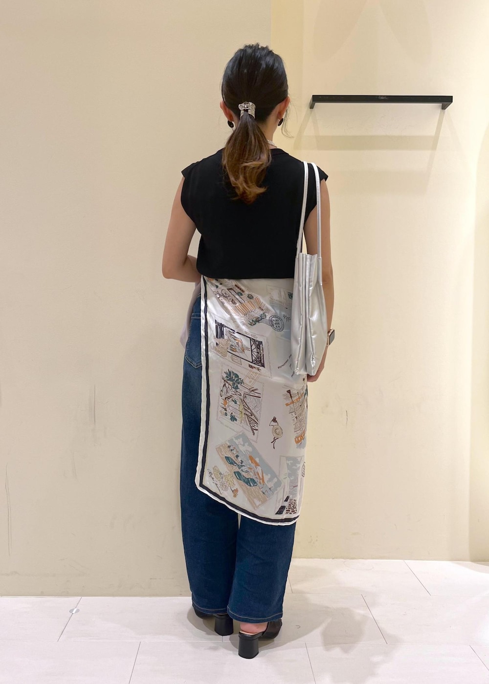 ブルー系のデニムパンツ、シルバー系のトートバッグ、ブラック系のパンプスを着用したレディースの夏コーディネートの3枚目の写真