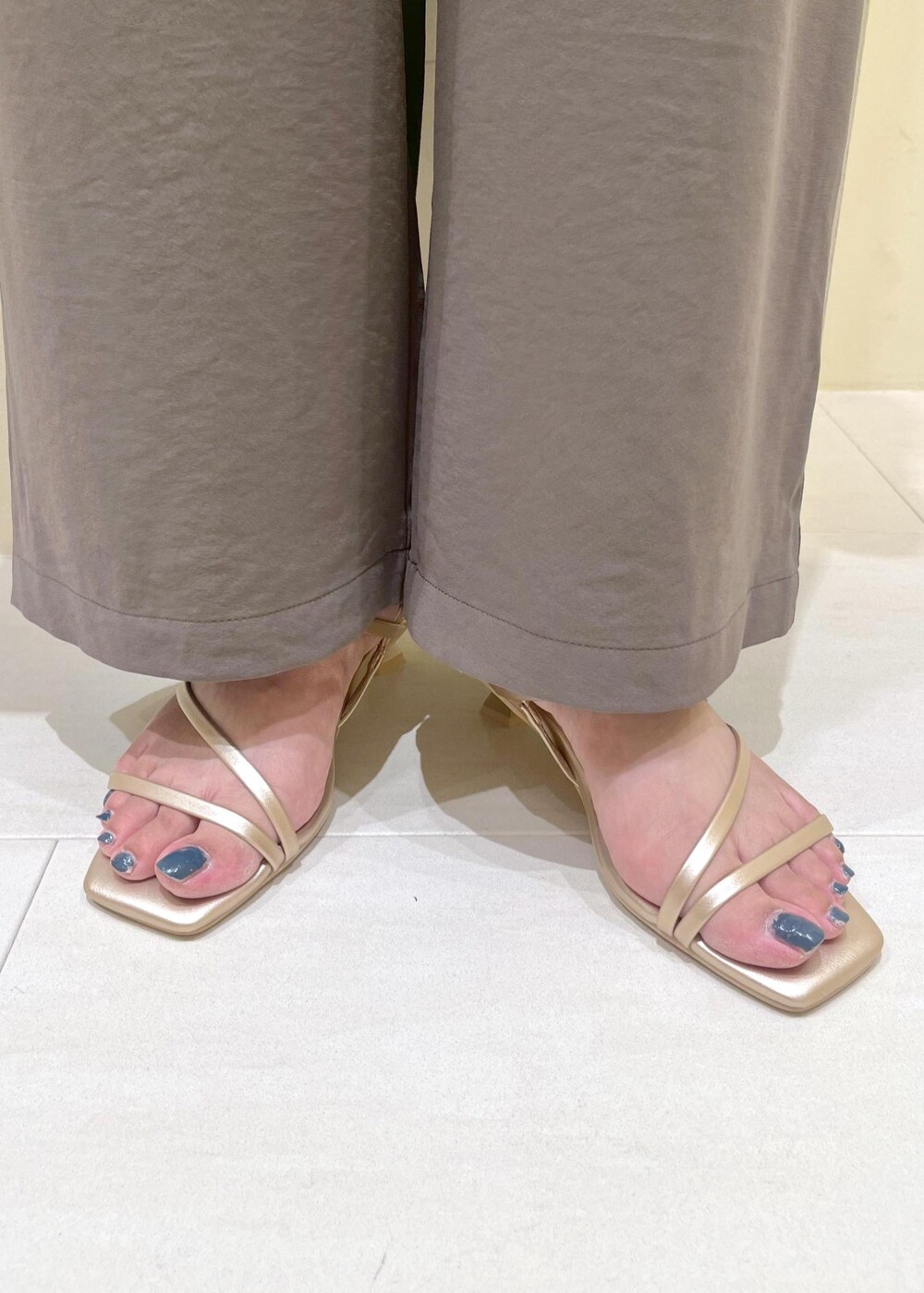 ゴールド系のサンダル、ベージュ系のハンドバッグ、グレー系のTシャツ/カットソーを着用したレディースの夏コーディネートの10枚目の写真