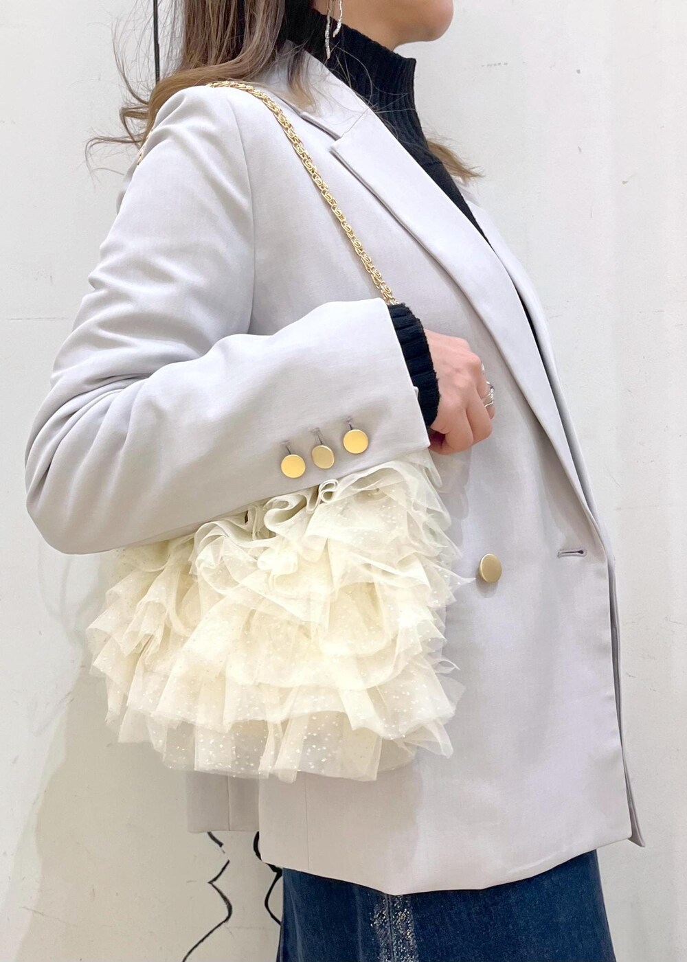 ブラック系のニット/セーター、ブラック系のニット/セーター、ブルー系のデニムスカートを着用したレディースの冬コーディネートの5枚目の写真