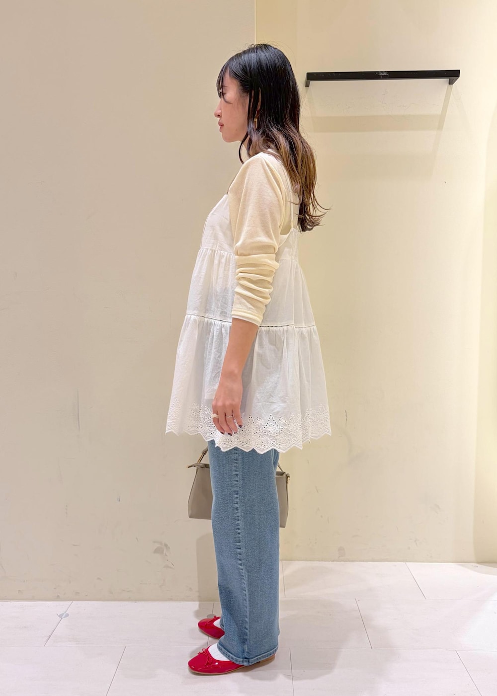 レッド系のバレエシューズ、ベージュ系のショルダーバッグ、ベージュ系のTシャツ/カットソーを着用したレディースの冬コーディネートの2枚目の写真