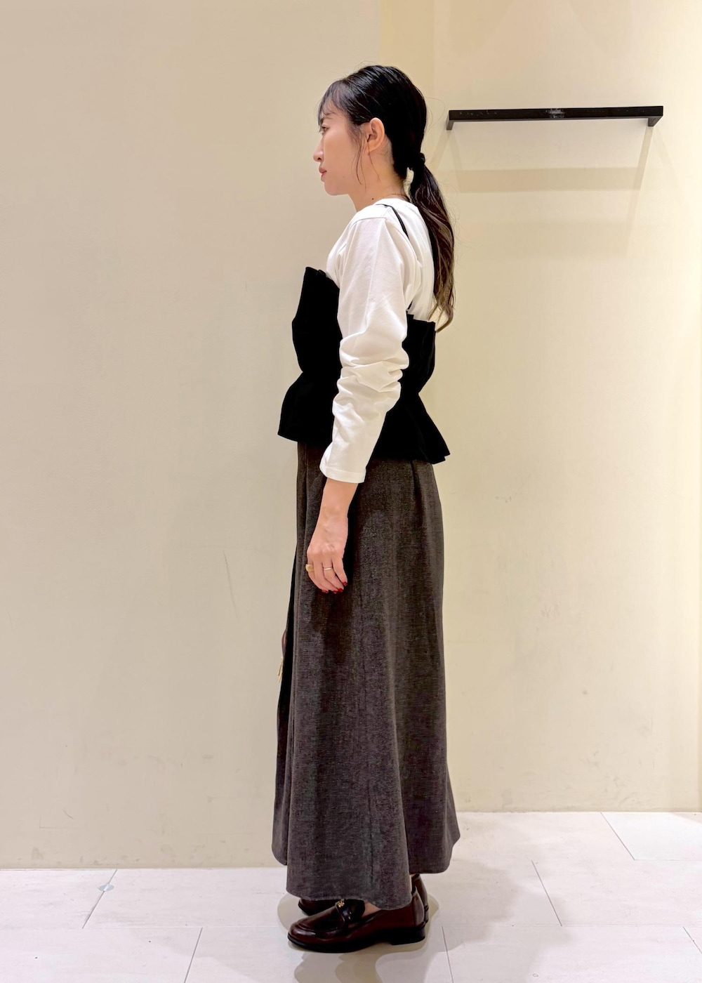ブラウン系のスカート、ホワイト系のTシャツ/カットソー、ブラック系のキャミソールを着用したレディースの秋コーディネートの4枚目の写真