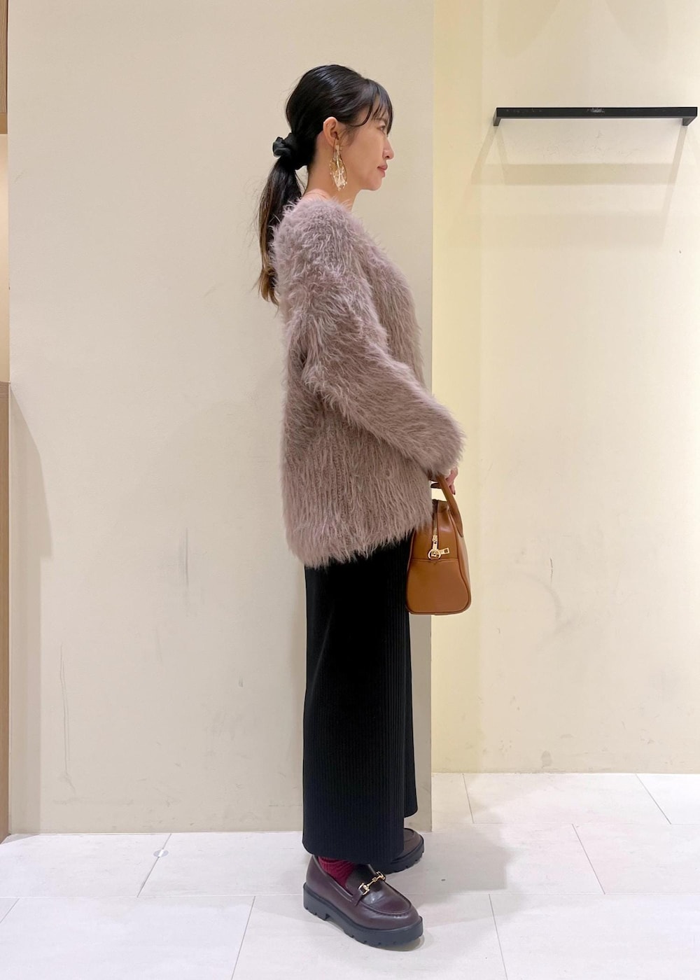 ホワイト系のTシャツ/カットソー、ブラウン系のニット/セーター、ブラウン系のローファーを着用したレディースの秋コーディネートの2枚目の写真