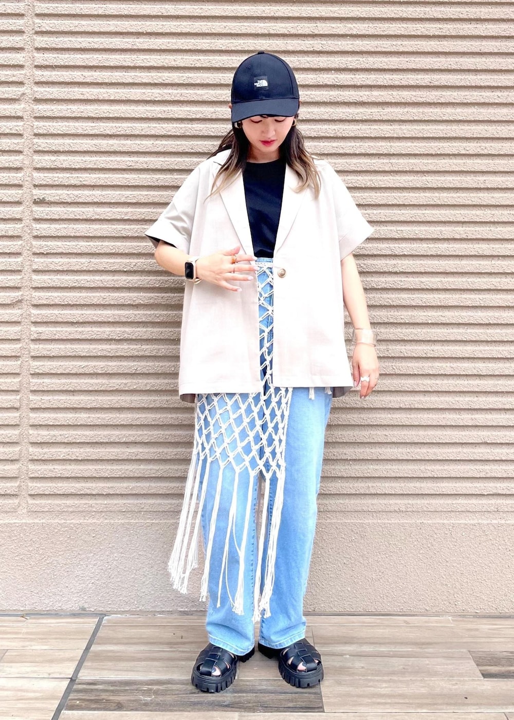 ブルー系のデニムパンツ、ホワイト系のスカート、ブラック系のTシャツ/カットソーを着用したレディースの春コーディネートの3枚目の写真