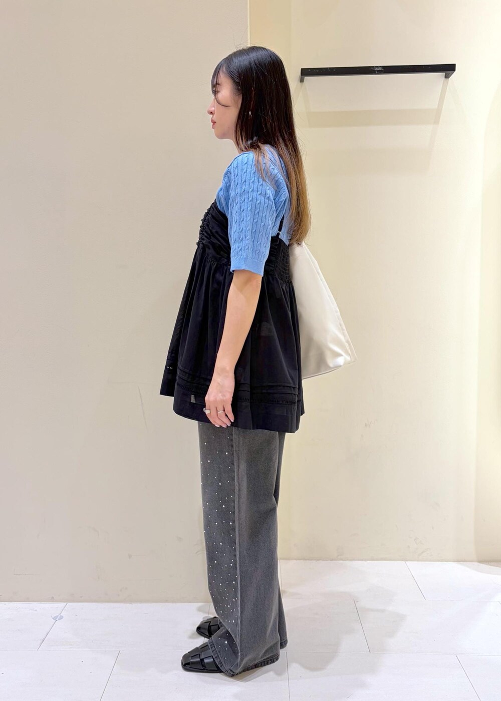 ブラック系のシャツ/ブラウス、ブルー系のニット/セーター、ブラック系のサンダルを着用したレディースの春コーディネートの2枚目の写真