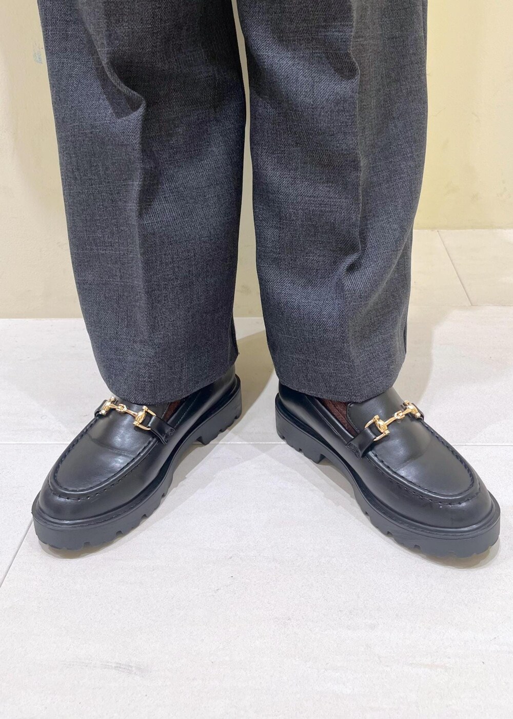 ブラック系のショルダーバッグ、ブラック系のニット/セーター、グレー系のスラックスを着用したレディースの秋コーディネートの10枚目の写真