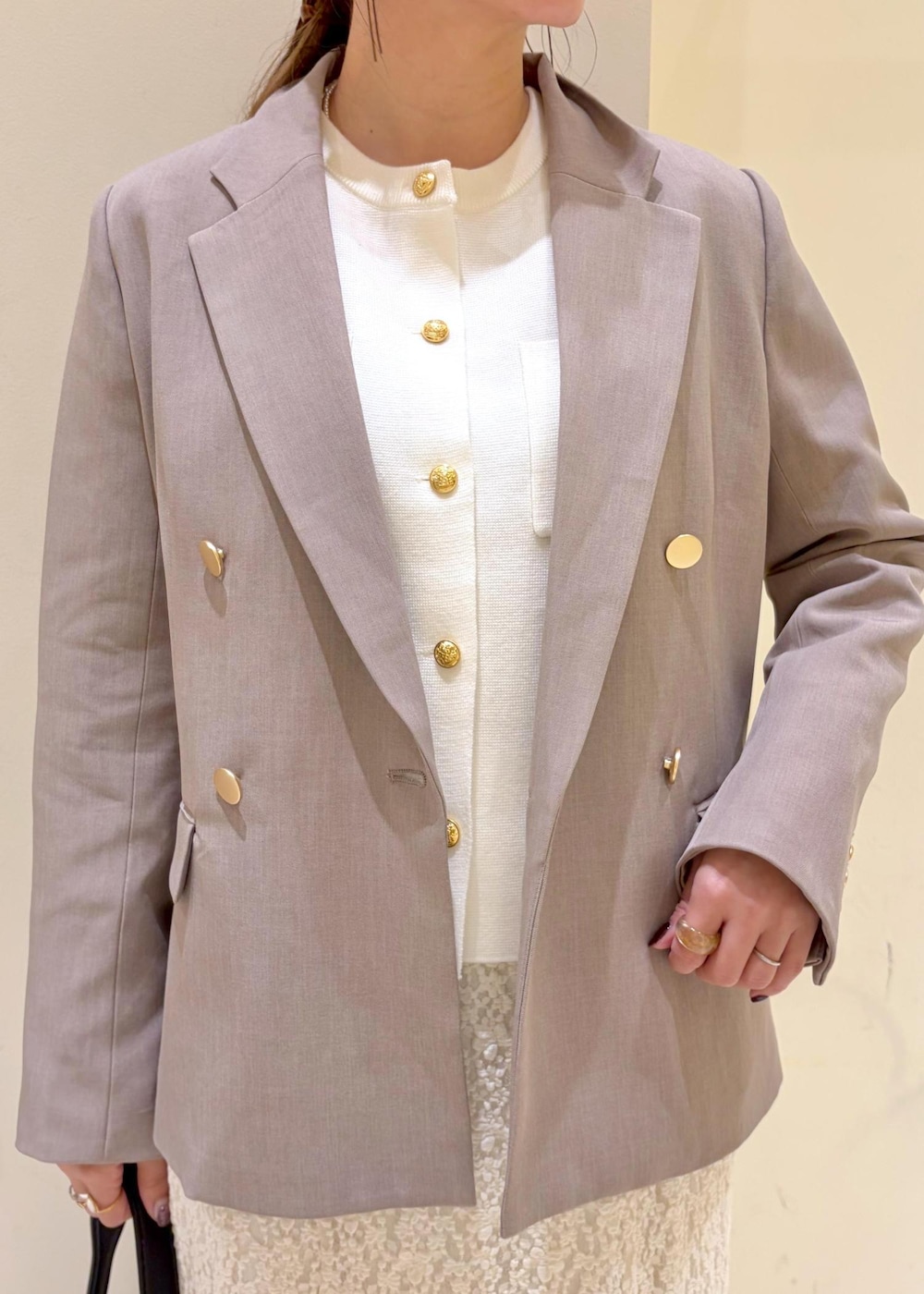 ブラック系のショルダーバッグ、ホワイト系のスカート、ホワイト系のカーディガン/ボレロを着用したレディースの冬コーディネートの5枚目の写真