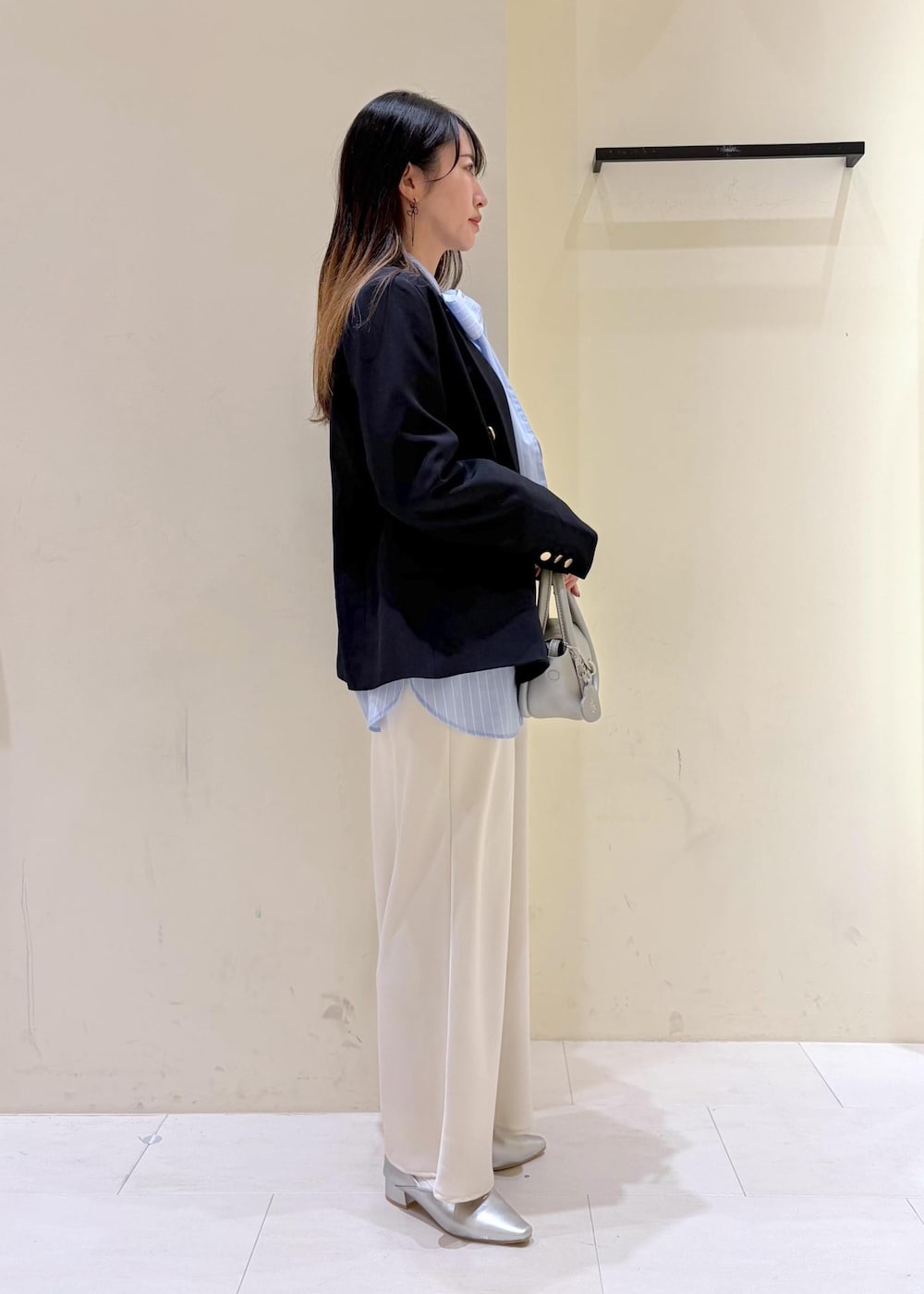 シルバー系のショルダーバッグ、ブルー系のテーラードジャケット、ブルー系のシャツ/ブラウスを着用したレディースの冬コーディネートの2枚目の写真