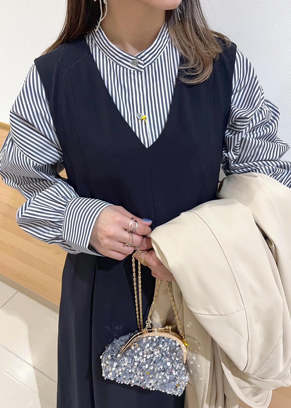 グレー系のショルダーバッグ、ブルー系のシャツ/ブラウス、ベージュ系のトレンチコートを着用したレディースの冬コーディネートの6枚目の写真