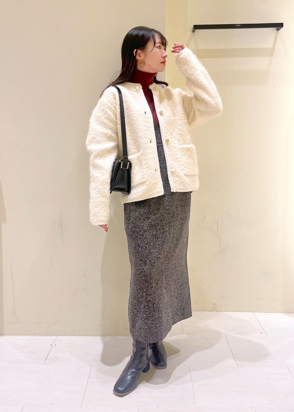 グレー系のジャンパースカート、ホワイト系のカーディガン/ボレロ、レッド系のニット/セーターを着用したレディースの冬コーディネートの9枚目の写真