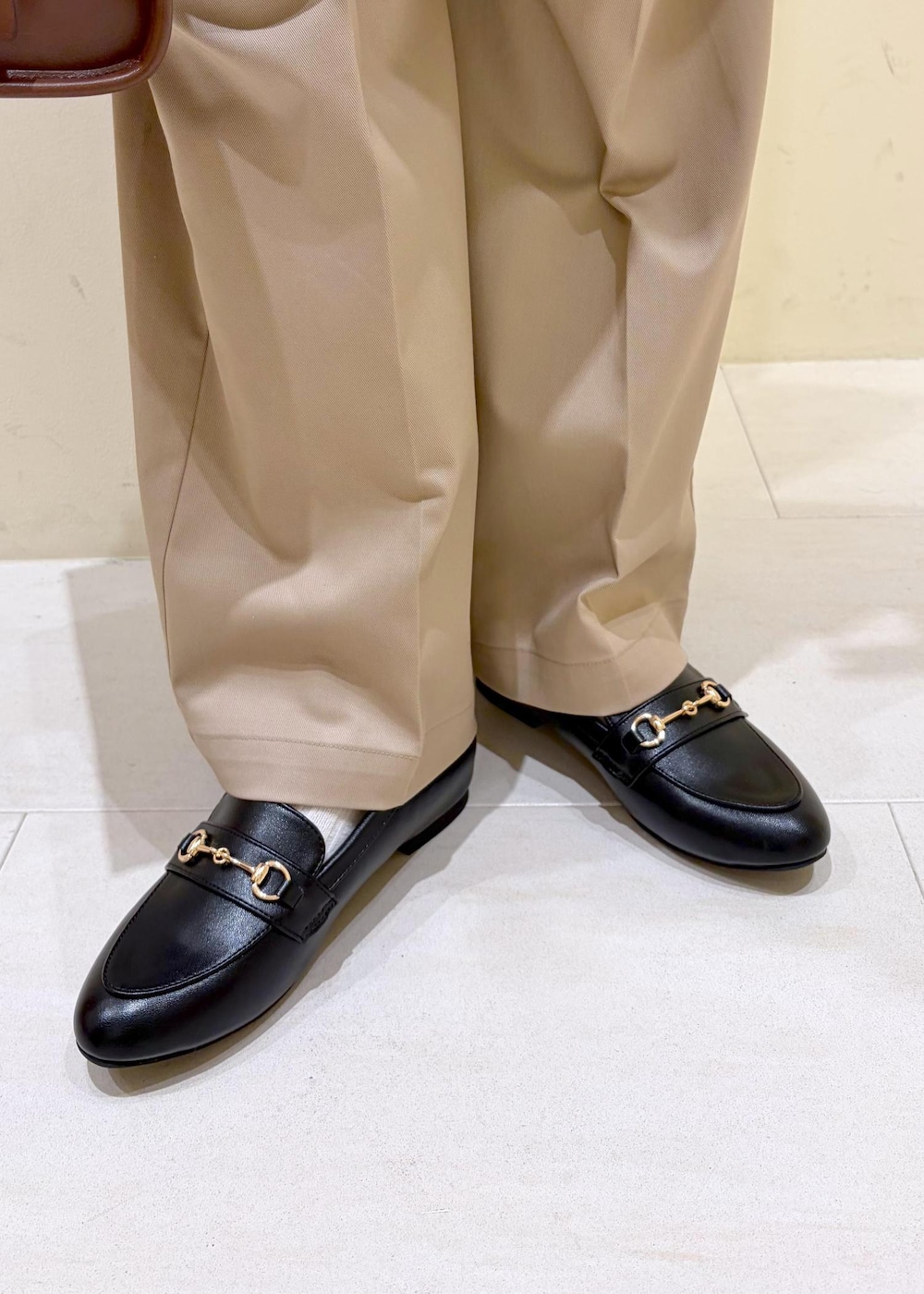 ブラック系のローファー、ブラウン系のボストンバッグ、ブルー系のテーラードジャケットを着用したレディースの冬コーディネートの10枚目の写真