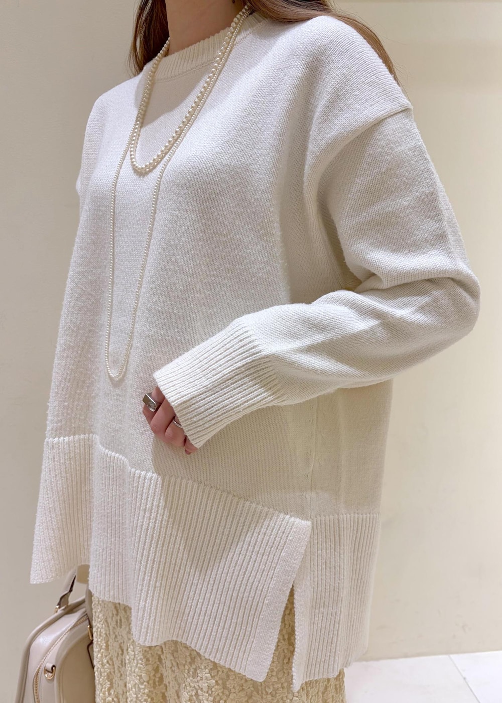 ホワイト系のバレエシューズ、ホワイト系のニット/セーター、ホワイト系のボストンバッグを着用したレディースの冬コーディネートの6枚目の写真