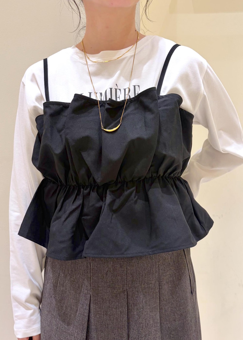 ブラウン系のスカート、ホワイト系のTシャツ/カットソー、ブラック系のキャミソールを着用したレディースの秋コーディネートの5枚目の写真