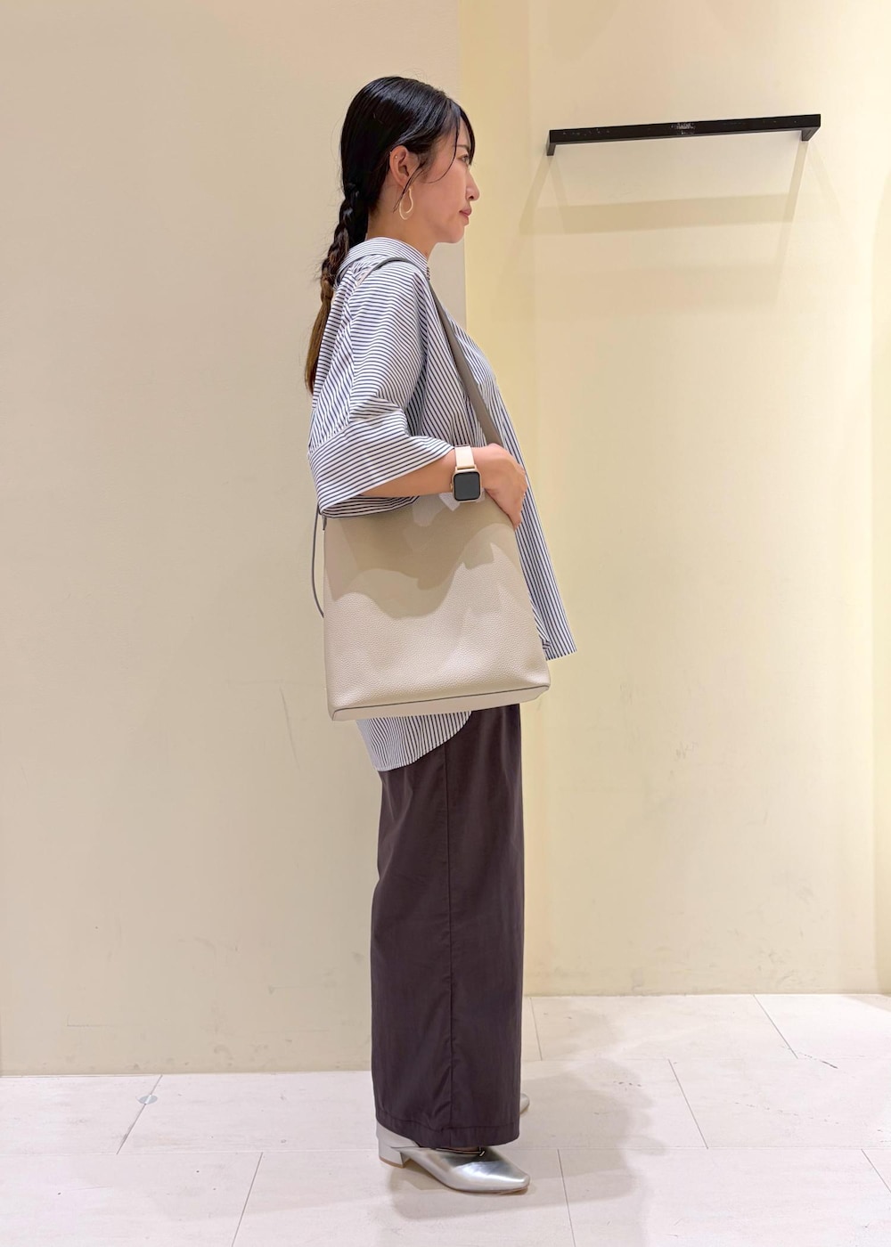 ブルー系のシャツ/ブラウス、ブラック系のニット/セーター、グレー系のその他パンツを着用したレディースの春コーディネートの2枚目の写真