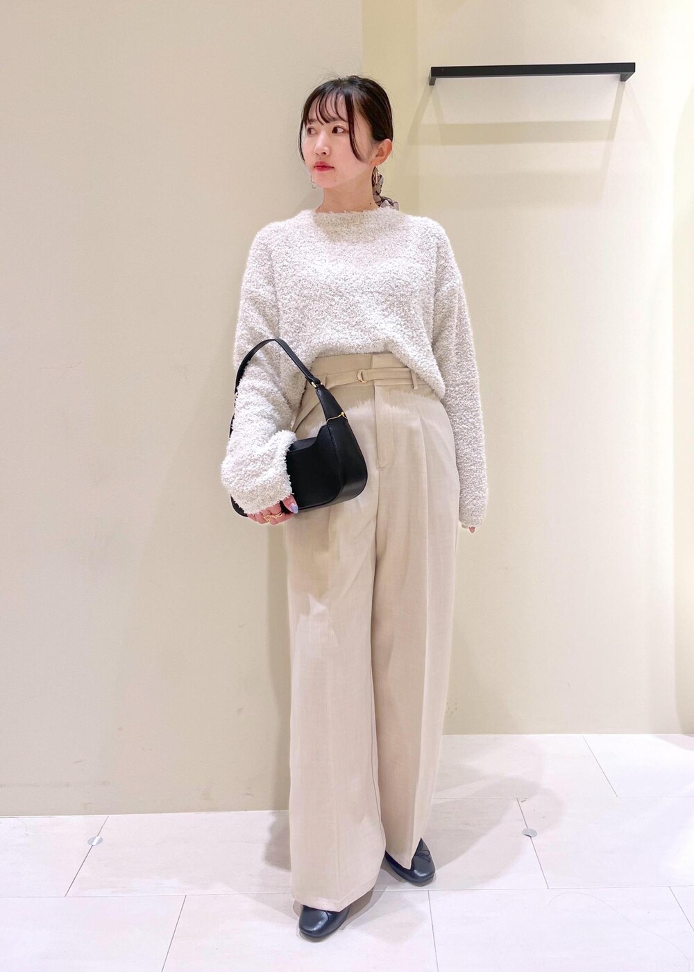 ブラック系のハンドバッグ、グレー系のニット/セーター、ブラック系のバレエシューズを着用したレディースの春コーディネートの2枚目の写真