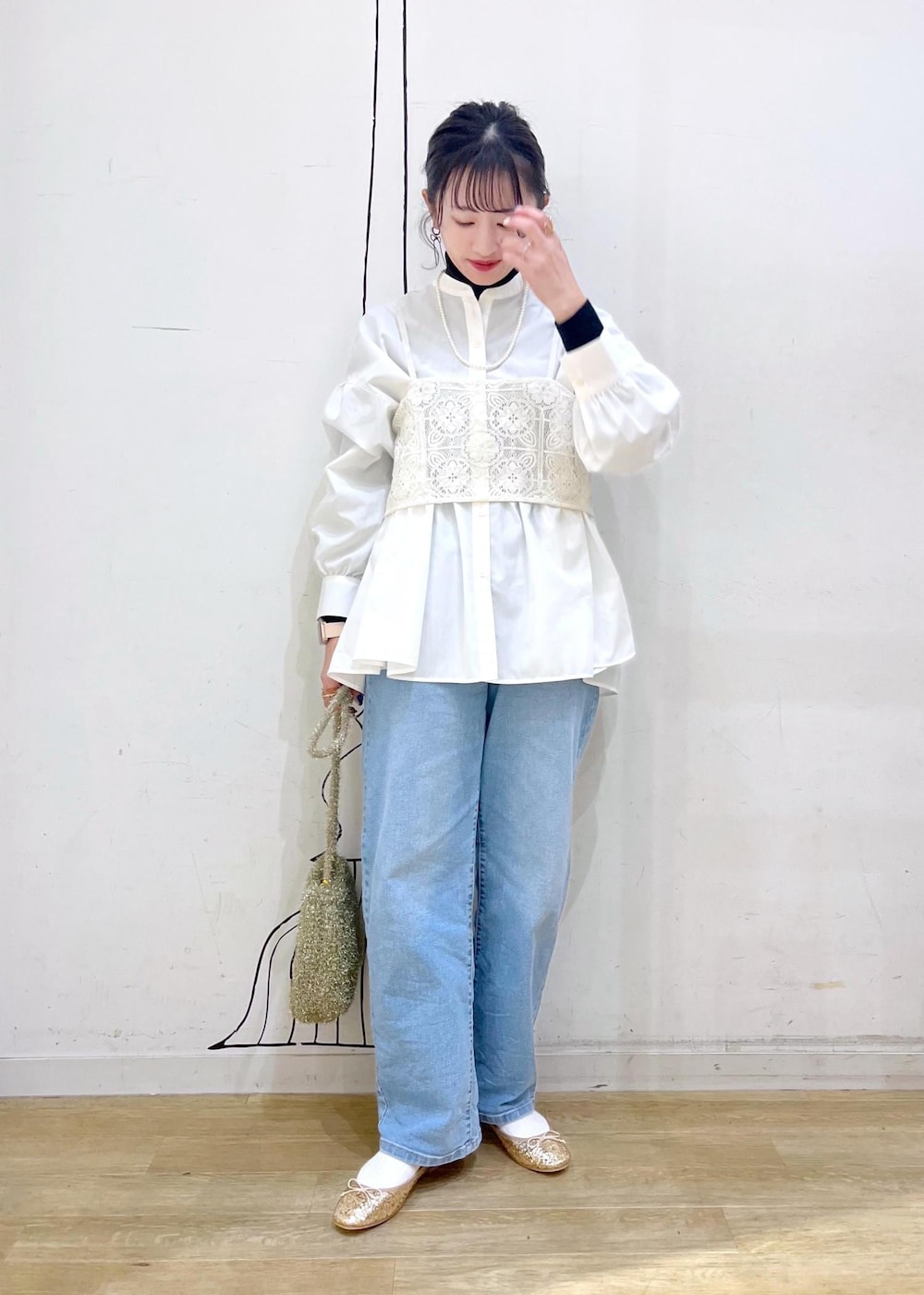 ブラック系のニット/セーター、ゴールド系のバレエシューズ、ホワイト系のキャミソールを着用したレディースの冬コーディネートの3枚目の写真